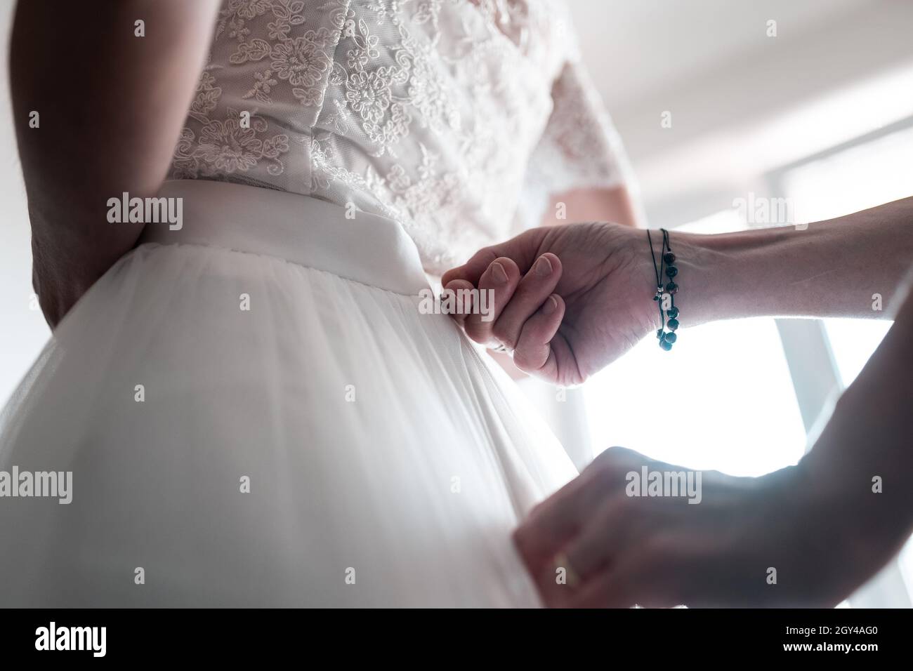 Hochzeitstag, Vorbereitung und Dressing Braut für die Zeremonie, Befestigung weißen Kleidern Stockfoto