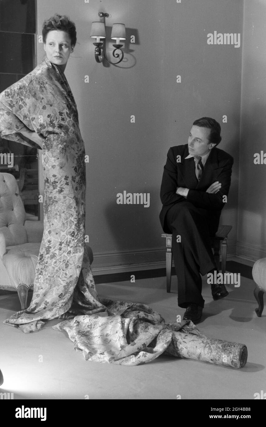 Der Modeschöpfer Heinz Schulze-Bibernell Und Ein Modell Bei der Anprobe Eines Kleides, Deutschland ca. 1939. Der Modeschöpfer Heinz Schulze-Bibernell und ein Modell, das versucht, ein Kleid, Deutschland ca. 1939. Stockfoto