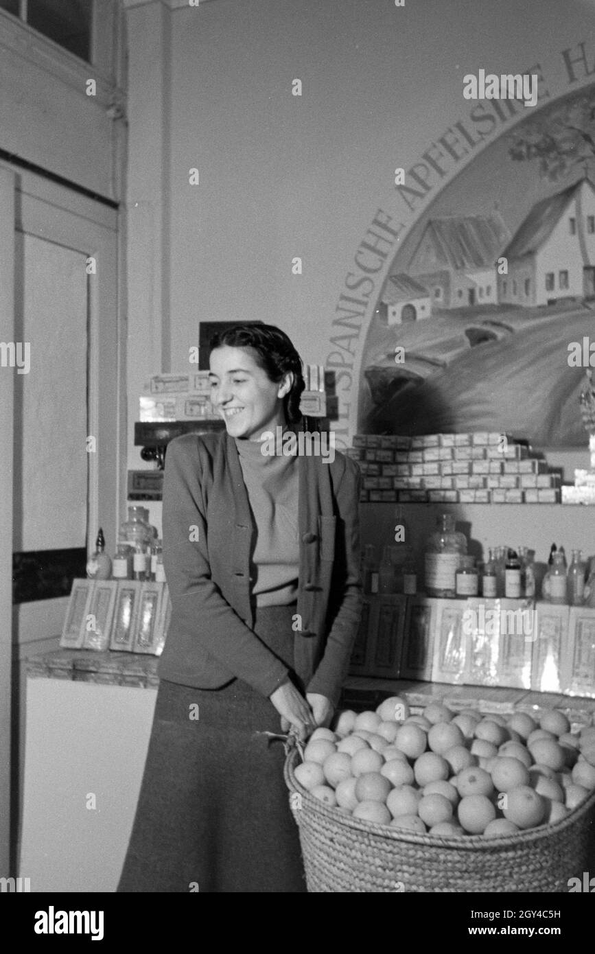 Angestellte der Leipziger Frühjahrsmesse vor einem Ständer mit spanischen Apfelsinen; Deutschland 1941. Mitarbeiter der Leipziger Frühjahrsmesse vor einem Ständer mit spanischen Orangen; Deutschland 1941. Stockfoto