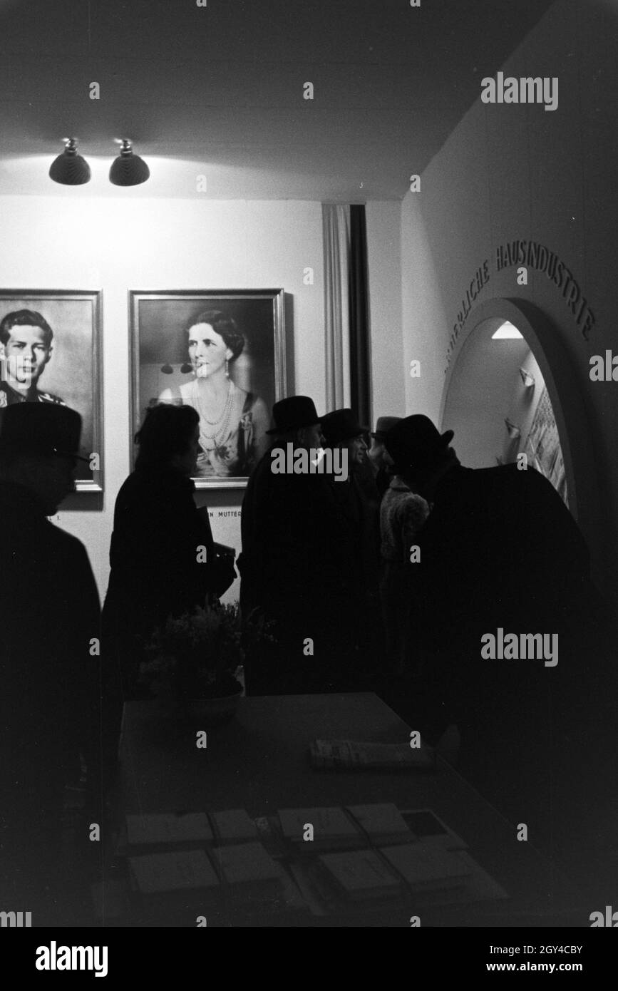 Besucher der Leipziger Frühjahrsmesse an einem rumenischen Stand mit Portraits des rumenischen Königs Michael I. und seiner Königinmutter Elena von Griechenland; Deutschland 1941. Besucher der Leipziger Frühjahrsmesse an einem rumänischen Stand mit Porträts des rumänischen Königs Michael I. und seiner Mutter Elena von Griechenland; Deutschland 1941. Stockfoto