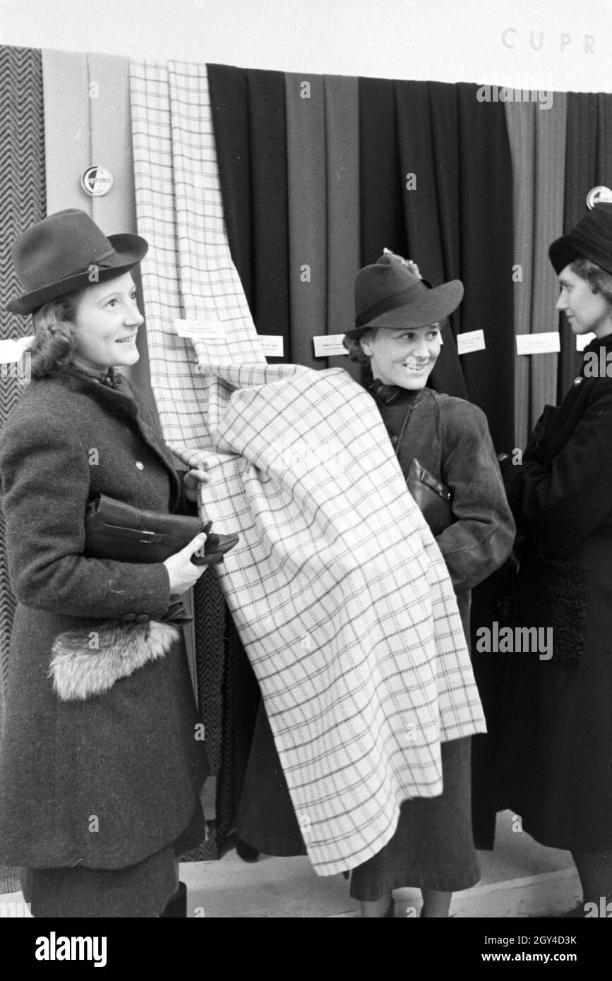 Frauen an einem Messestand des Konzerns I.G. Farbenindustrie mit Aceta-Kunstseide, anlässlich der Wiener Modewoche im Haus der Mode ' Palais Lobkowitz', Deutschland 1940er Jahre. Frauen an einem Stand der Firma I.G. Farbenindustrie mit Aceta-Kunstseide, anlässlich der Wiener Modewoche im Haus der Mode ' Palais Lobkowitz', Deutschland 1940er Jahre. Stockfoto