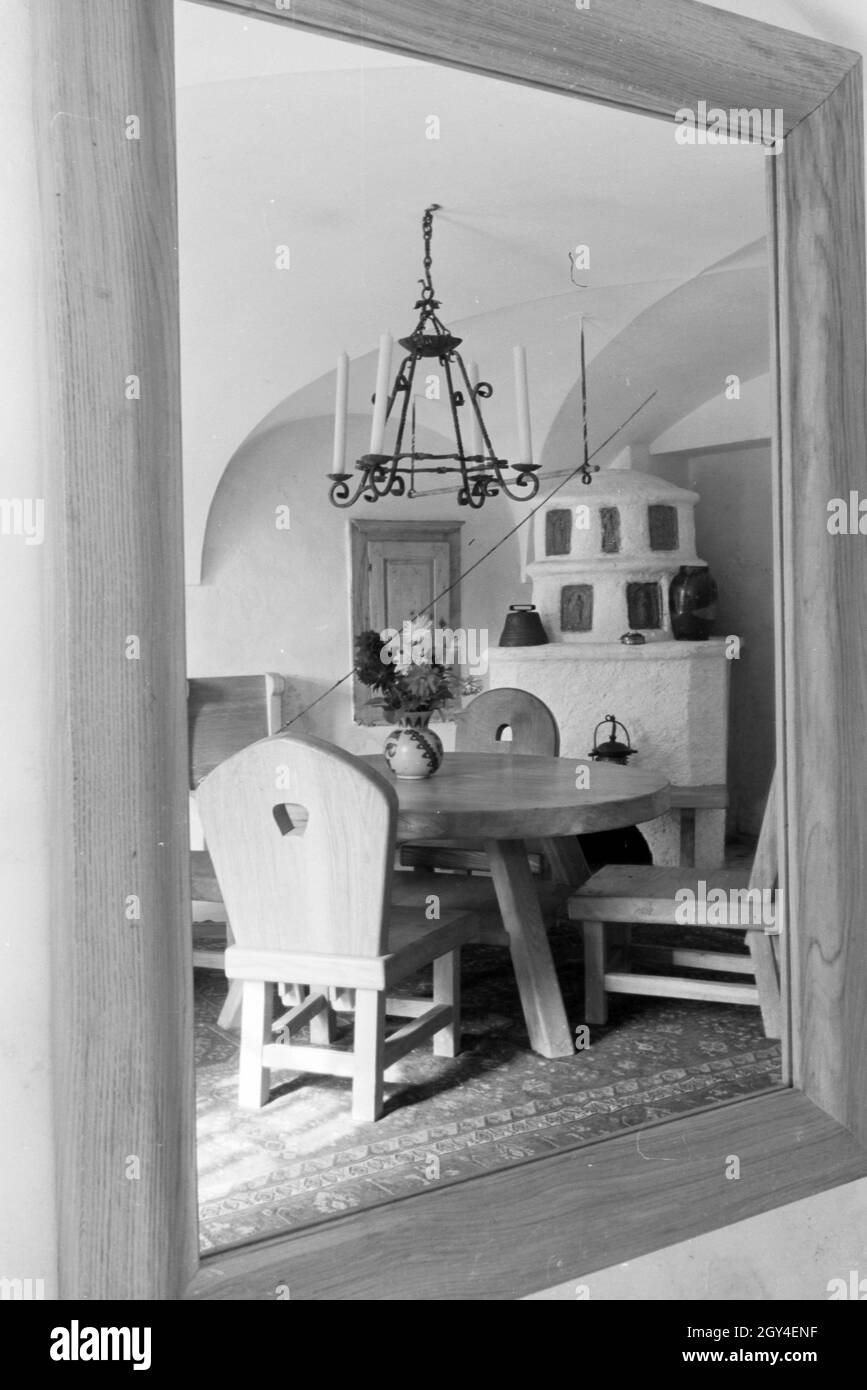 Ansicht vom Esszimmer mit Holzmöbeln und Kamin auf Schloss Hartmannsberg, Residenz von Bildhauer Josef Thorak, Deutschland 1930er Jahre. Blick auf einen Speisesaal mit Holzmöbeln in Hartmannsberg schloss, die Residenz der Bildhauer Josef Thorak, Deutschland 1930. Stockfoto