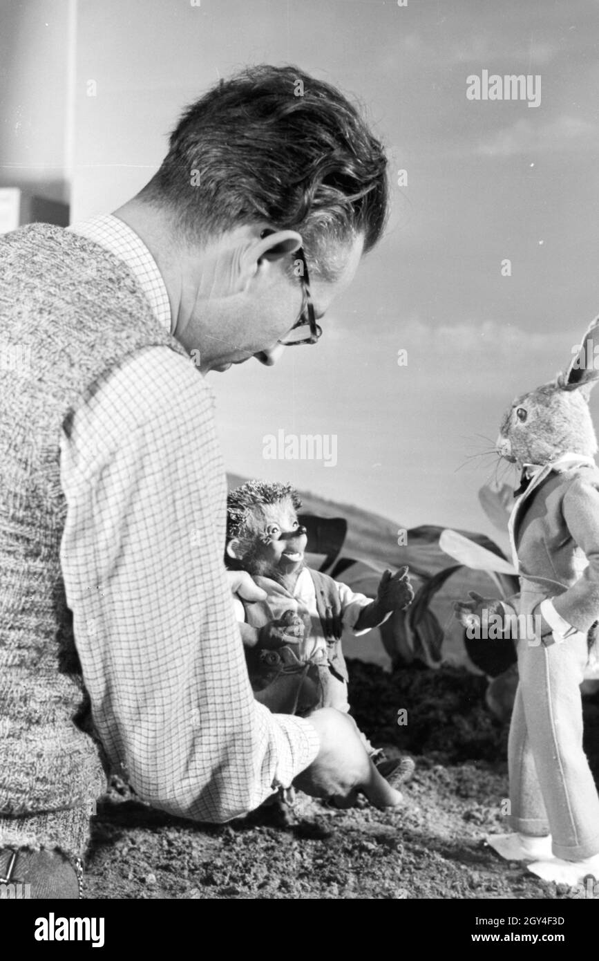 Filmaufnahmen mit dem Satz vom Puppenfilm "Der Wettlauf zwischen dem Hasen und dem Igel mit der Figur Mecki, unter der Produktion und Leitung der Gebrüder Diehl, Deutschland 1930er Jahre. Die Dreharbeiten zu dem Satz der Marionette Film Der Hase und der Igel mit der Charakter Mecki, produziert und durch die Diehl Brüder geleitet, Deutschland 1930. Stockfoto