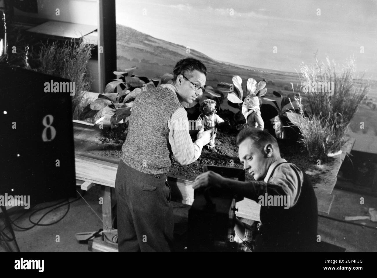 Filmaufnahmen mit dem Satz vom Puppenfilm "Der Wettlauf zwischen dem Hasen und dem Igel mit der Figur Mecki, unter der Produktion und Leitung der Gebrüder Diehl, Deutschland 1930er Jahre. Die Dreharbeiten zu dem Satz der Marionette Film Der Hase und der Igel mit der Charakter Mecki, produziert und durch die Diehl Brüder geleitet, Deutschland 1930. Stockfoto