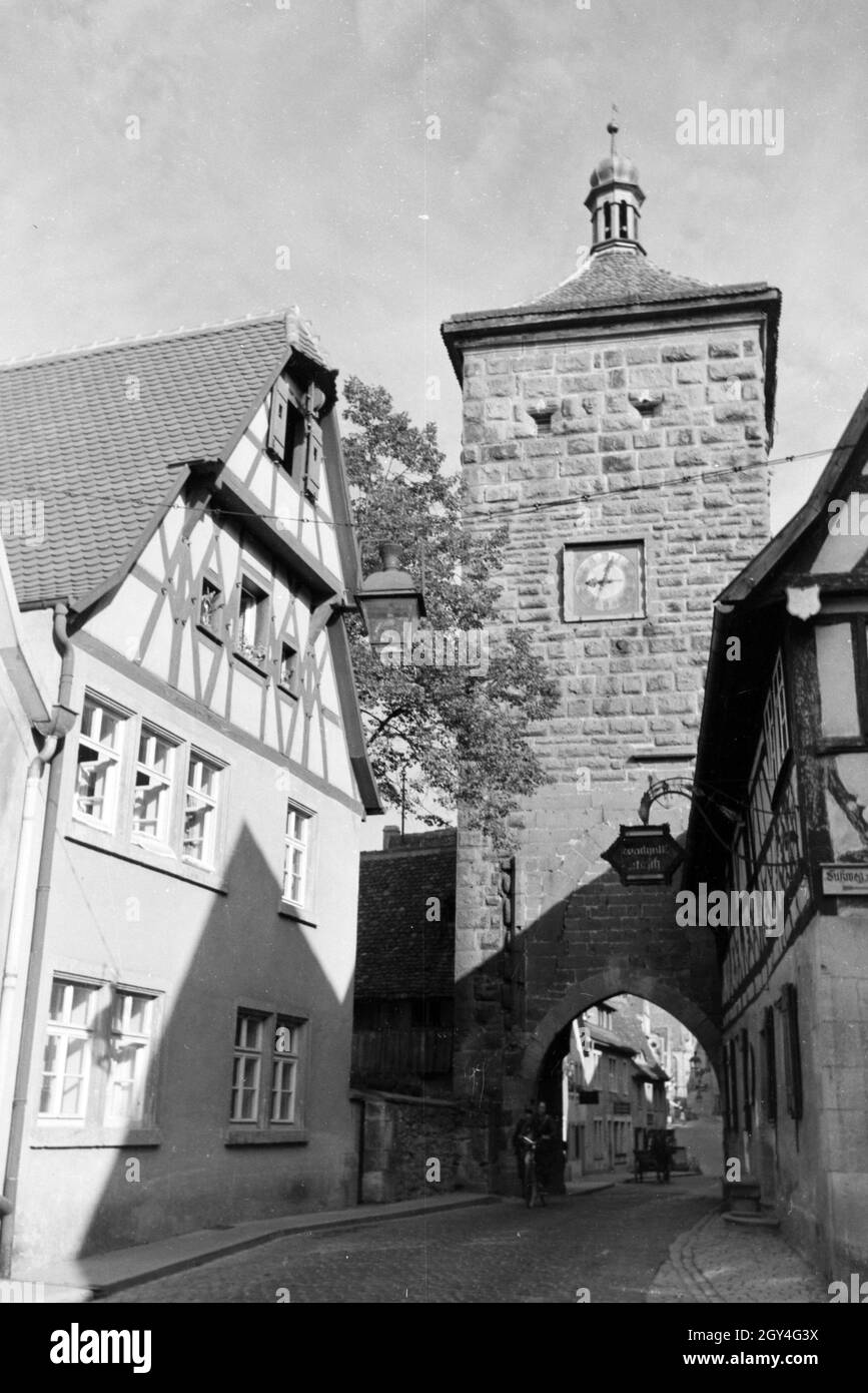 Ein Fahrradfahrer fährt durch das Sieberstor in Rothenburg o.d. Tauber, Deutschland 1930er Jahre. Ein Radfahrer fährt durch die siebers Gate/Sieberstor in Rothenburg o.d. Tauber, Deutschland 1930. Stockfoto