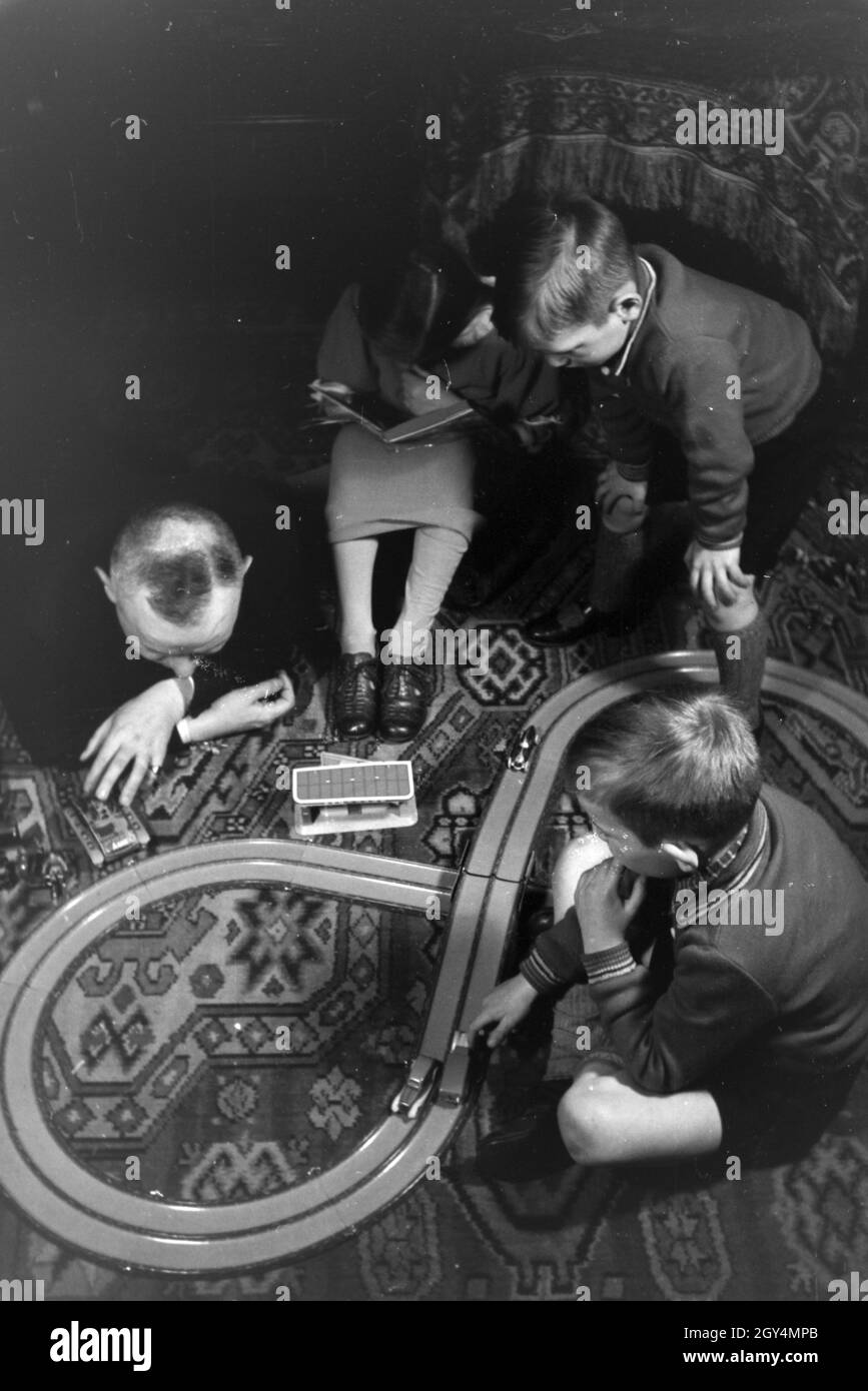 Mitglieder einer kinderreichen Familie spielen im Wohnzimmer, Deutsches Reich 30er Jahre. Mitglieder einer Familie spielen im Wohnzimmer, Deutschland 1930. Stockfoto