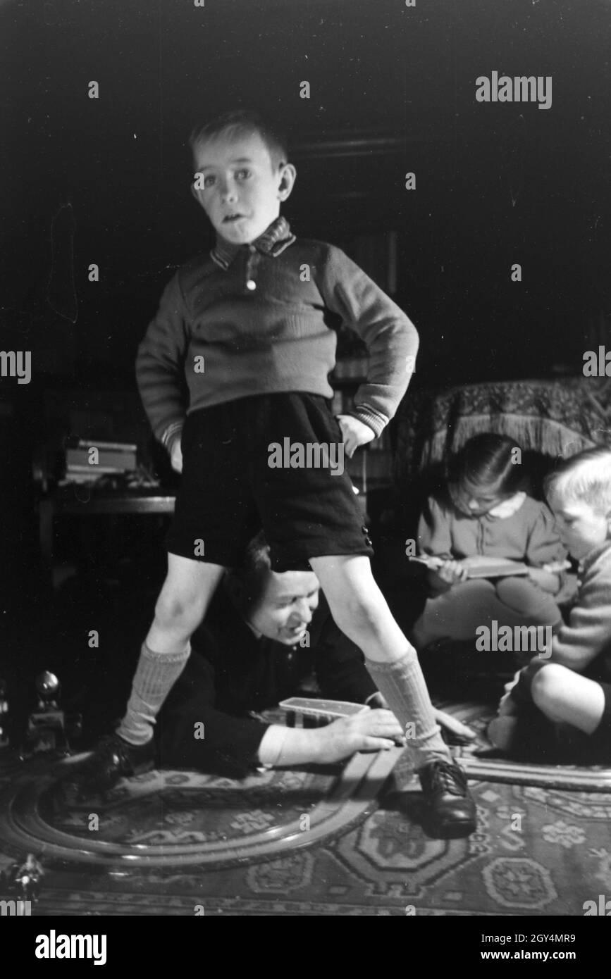 Mitglieder einer kinderreichen Familie spielen im Wohnzimmer, Deutsches Reich 30er Jahre. Mitglieder einer Familie spielen im Wohnzimmer, Deutschland 1930. Stockfoto