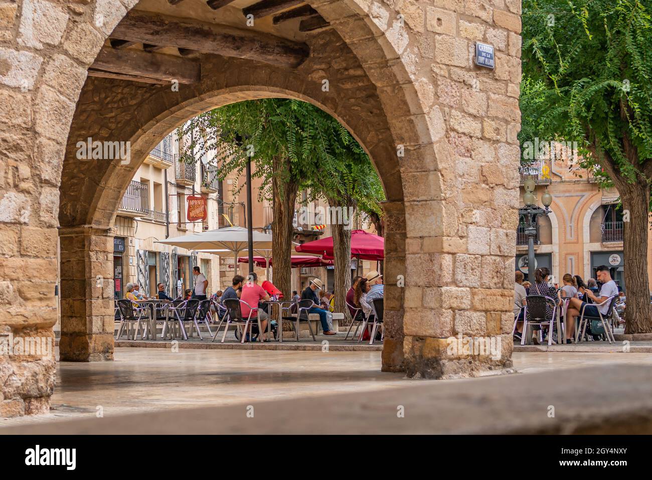 MONTBLANC, SPANIEN - SEPTEMBER 12. 2021: Die alte Straße mit Menschen im historischen Viertel des antiken spanischen Dorfes Montblanc. Menschen im Café Stockfoto
