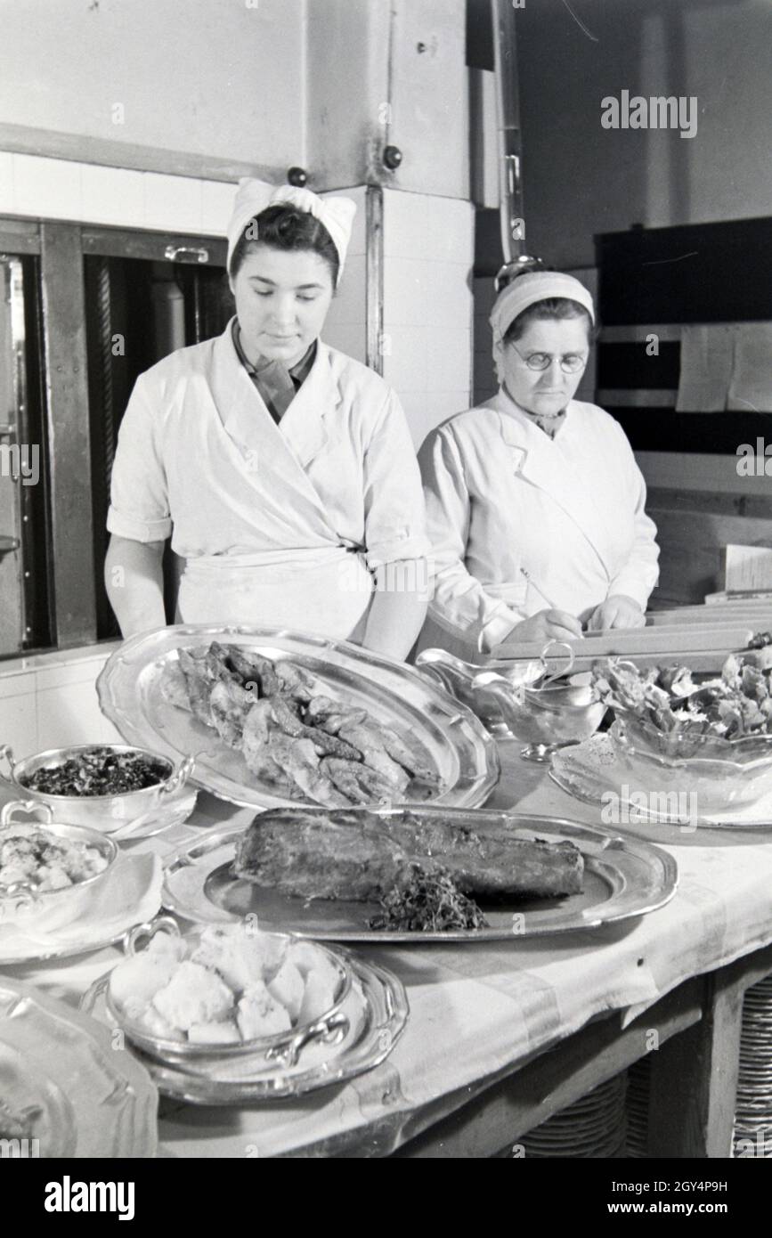 Frauen bereiten eine Mahlzeit in der Küche einer Gaststätte, Deutschland 1930er Jahre. Frauen bei der Zubereitung der Gerichte in der Küche eines Restaurants, Deutschland 1930. Stockfoto