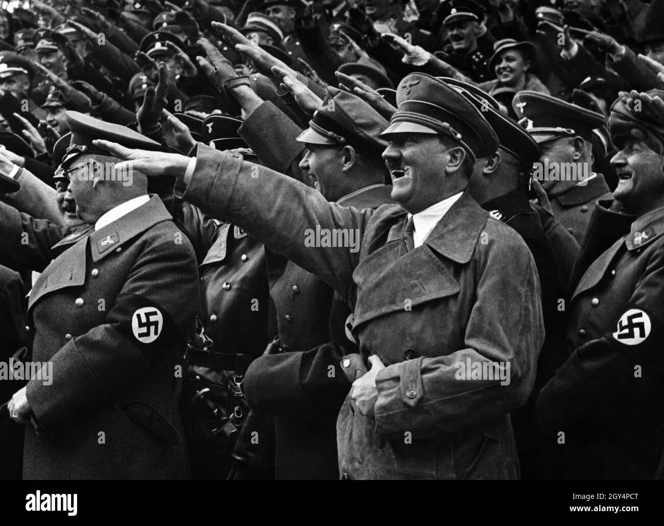 Reichskanzler Adolf Hitler in guter Laune im Trenchcoat mit Hitlers Gruß. [Automatisierte Übersetzung] Stockfoto