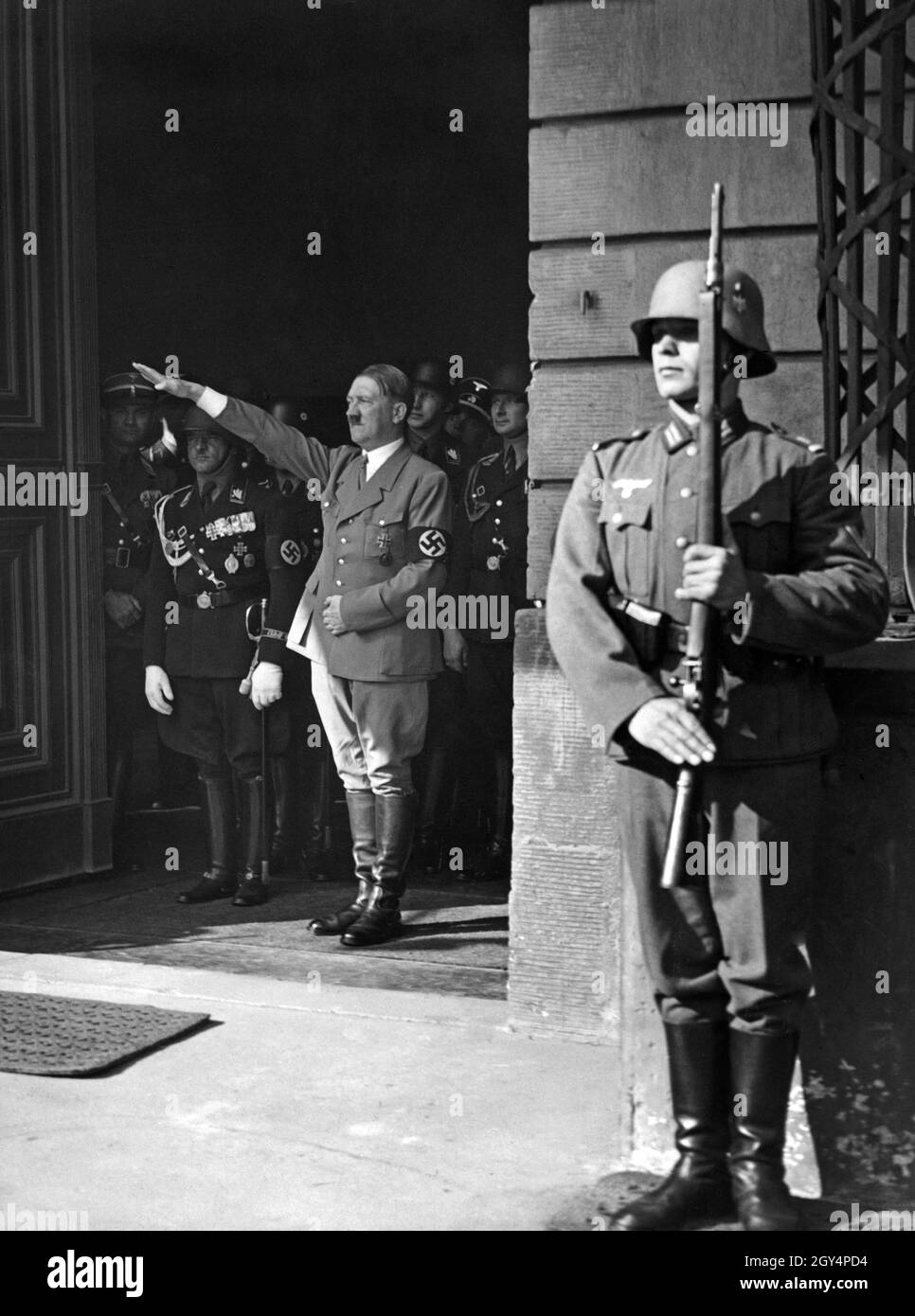 Mit dem Hitlergruß begrüßt der Diktator an seinem Geburtstag 1936 im Hof der Reichskanzlei die Glückwünsche. Rechts von Hitler steht der Obergruppenführer Sepp Dietrich, der das Ärmelband der Leibstandarte der SS Adolf Hitler trägt. [Automatisierte Übersetzung] Stockfoto