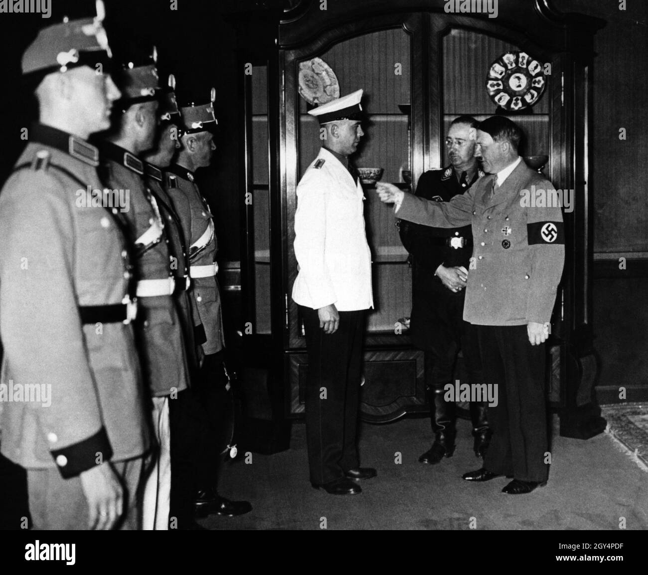 Reichsführer SS und Polizeichef Heinrich Himmler zeigt Adolf Hitler neue Entwürfe von Polizeiuniformen. Mitglieder der Ordnungspolizei wie diese waren auch an den Massakern an der Ostfront im Rahmen von Reserve-Bataillonen beteiligt und lieferten politischen Terror zu Hause durch das Nazi-Regime. [Automatisierte Übersetzung] Stockfoto