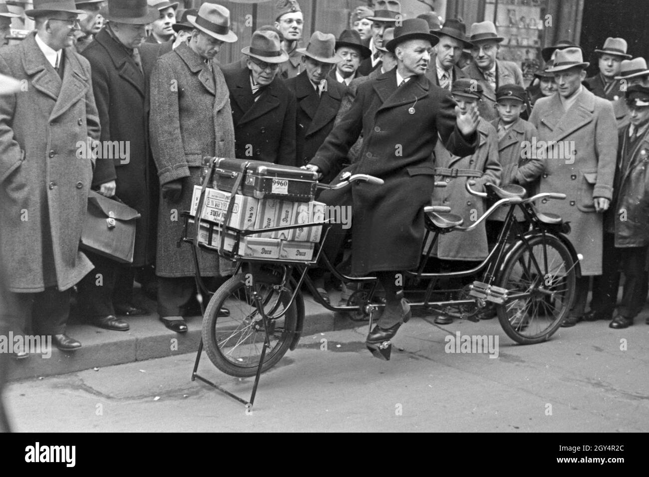 Ein Mann stellt in der Innenstadt von Leipzig zur Messe ein Liefertandem vor, Deutschland 1940er Jahre. Ein Mann, der Förderung einer Tandem in der Stadt Leipzig auf der Messe, Deutschland 1940. Stockfoto