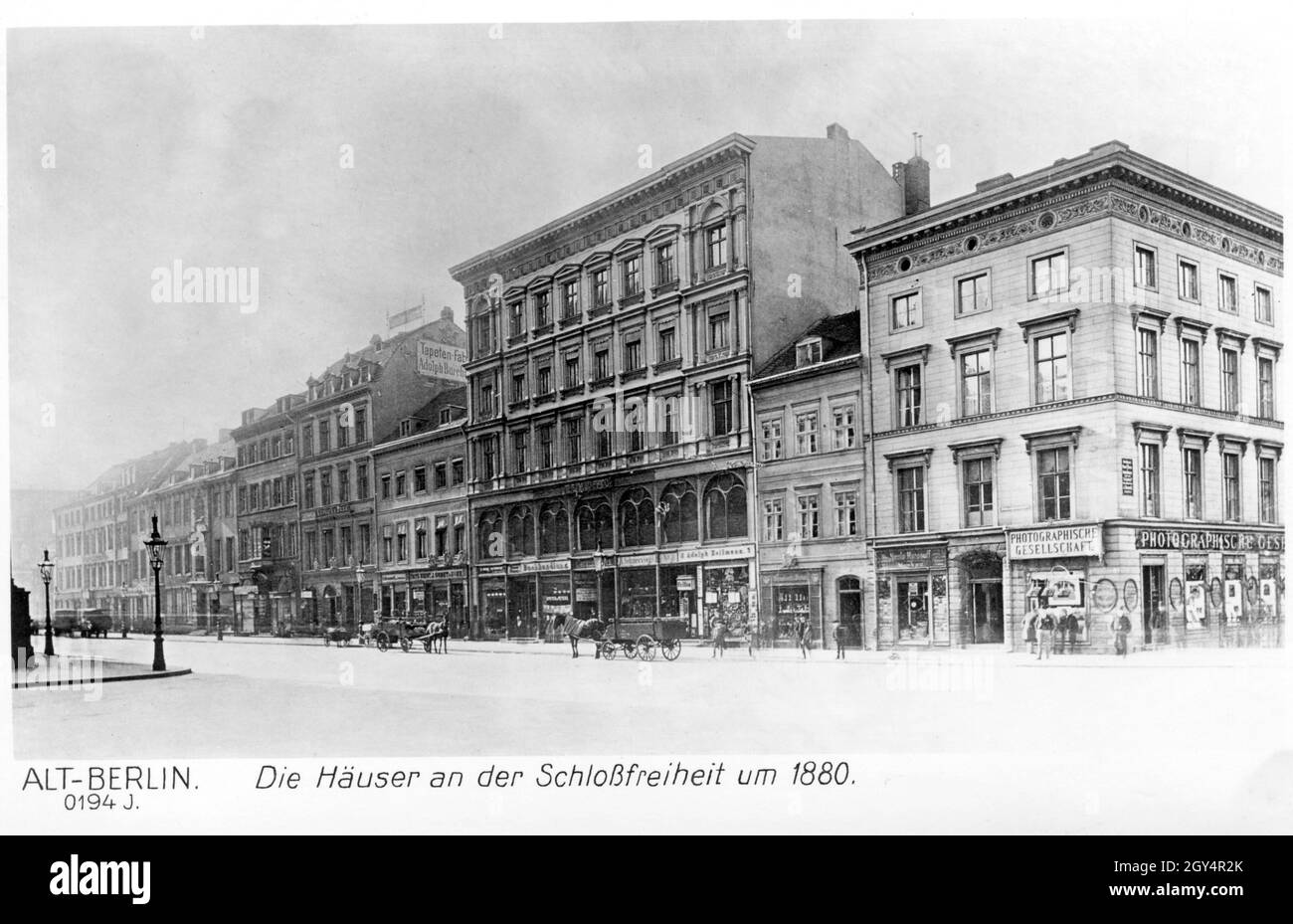 'Dieses Foto, aufgenommen um 1880, zeigt die Schloßfreiheit im Berliner Schloss in Berlin-Mitte. Die Häuser wurden später für den Bau des Kaiser-Wilhelm-Nationaldenkmals abgerissen. Die Häuser enthalten verschiedene Geschäfte, darunter (von rechts nach links): ''Photographische Gesellschaft'', ''Nicolai Marosoff'', ''Brillen Adolph Heilmann'', ''R. Schneevogl'', eine Buchhandlung und die 'Tapeten-Fabrik Adolph Burchardt'. [Automatisierte Übersetzung]' Stockfoto