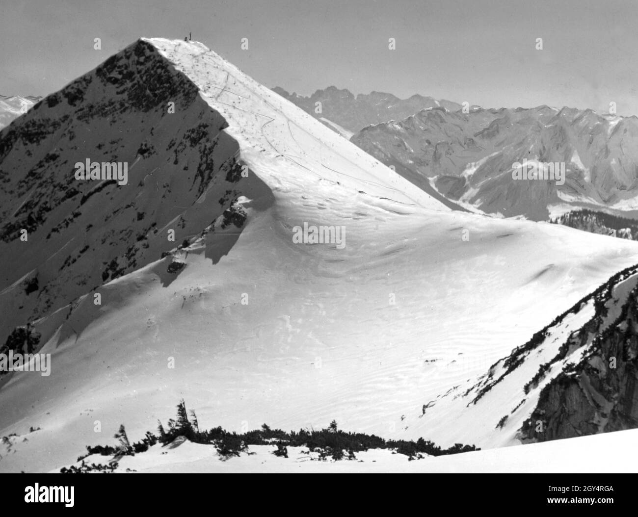 Die Wege führen durch den tiefen Schnee zum Gipfel des Geigelsteins in den Chiemgauer Alpen. Der Blick geht Richtung Süden auf das Kaisergebirge. Undatierte Fotografie, wahrscheinlich um 1930 aufgenommen. [Automatisierte Übersetzung] Stockfoto