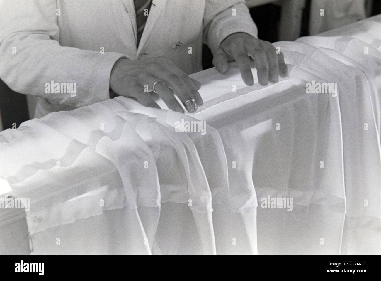 Hände des Vorarbeiters Fallschirm in einer Näherei, Deutschland 1940er Jahre. Hände von einem häuptling an einem Fallschirm nähen Fabrik, Deutschland 1940. Stockfoto