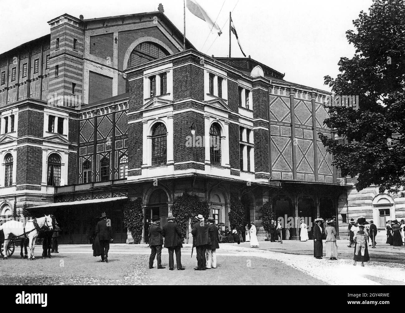 Dieses Foto zeigt das Richard Wagner Festspieltheater in Bayreuth im Jahr 1912, mit einer High Society, die sich westlich des Haupteingangs versammelt, vermutlich für eine Opernaufführung bei den Bayreuther Festspielen. [Automatisierte Übersetzung] Stockfoto