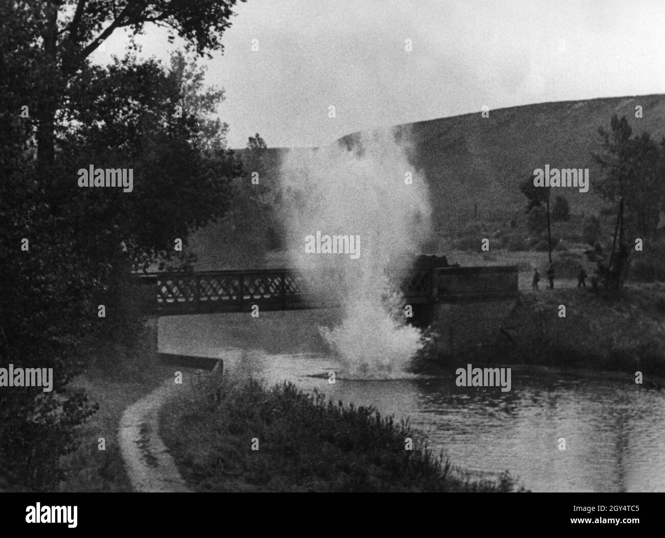 Auszug aus einem Propagandakriegsfilm: Vor einer Brücke trifft eine Bombe auf das Wasser. [Automatisierte Übersetzung] Stockfoto