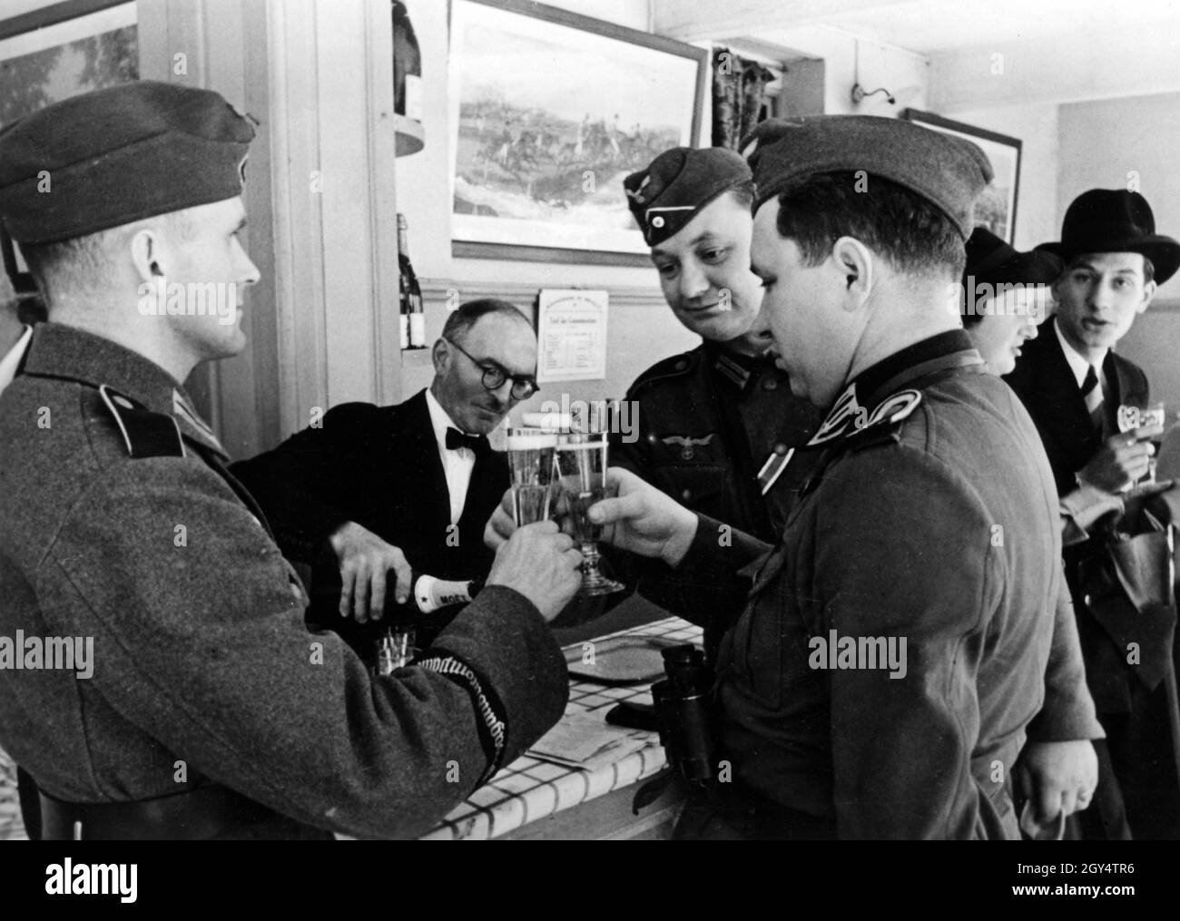 Soldaten der deutschen Wehrmacht stoßen auf einem Rasenplatz in Bordeaux mit Champagner auf ihren Sieg an. [Automatisierte Übersetzung] Stockfoto