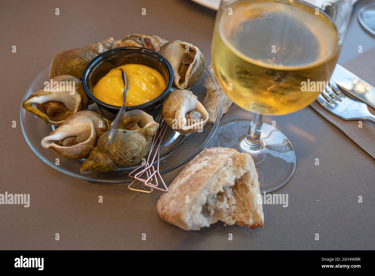 Perfekte Paarung: Ein Jurançon Wein und einige Meeresfrüchte, hier: bulot. Bassin d'Arcachon, Frankreich Stockfoto