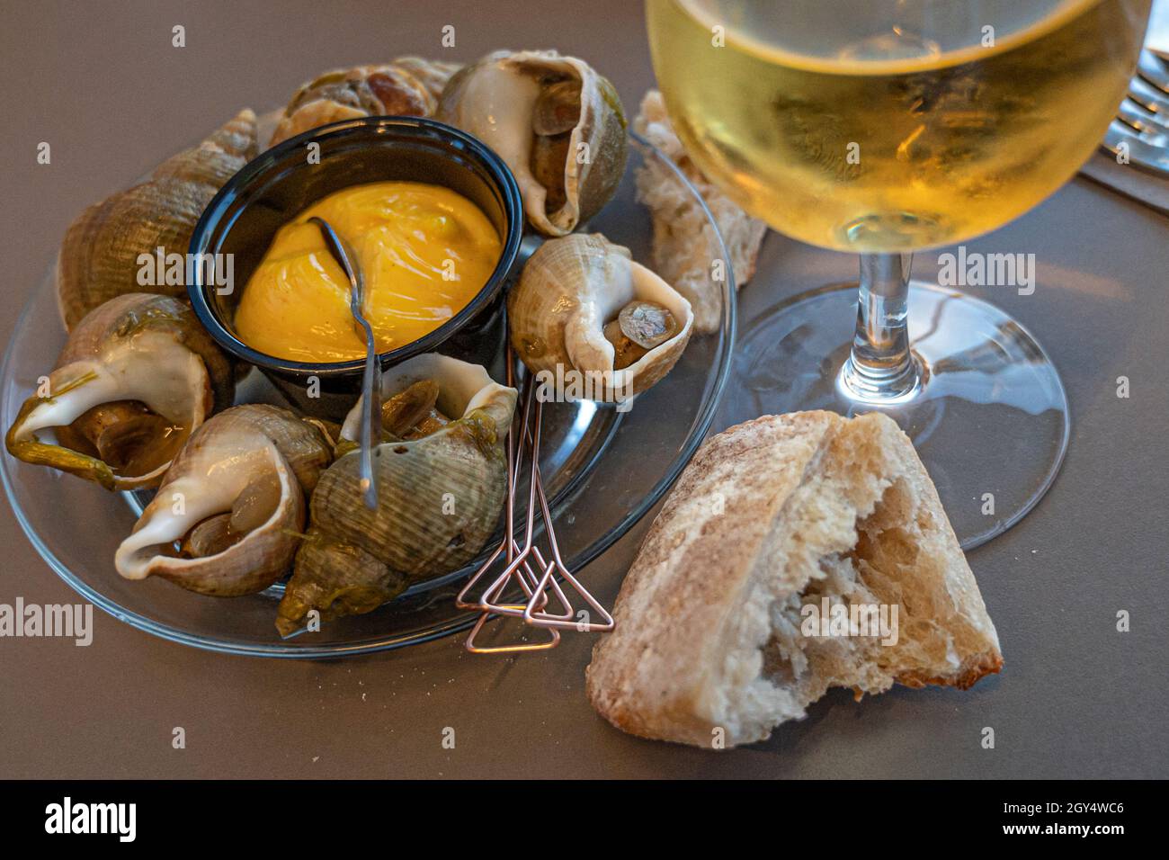 Perfekte Paarung: Ein Jurançon Wein und einige Meeresfrüchte, hier: bulot. Bassin d'Arcachon, Frankreich Stockfoto