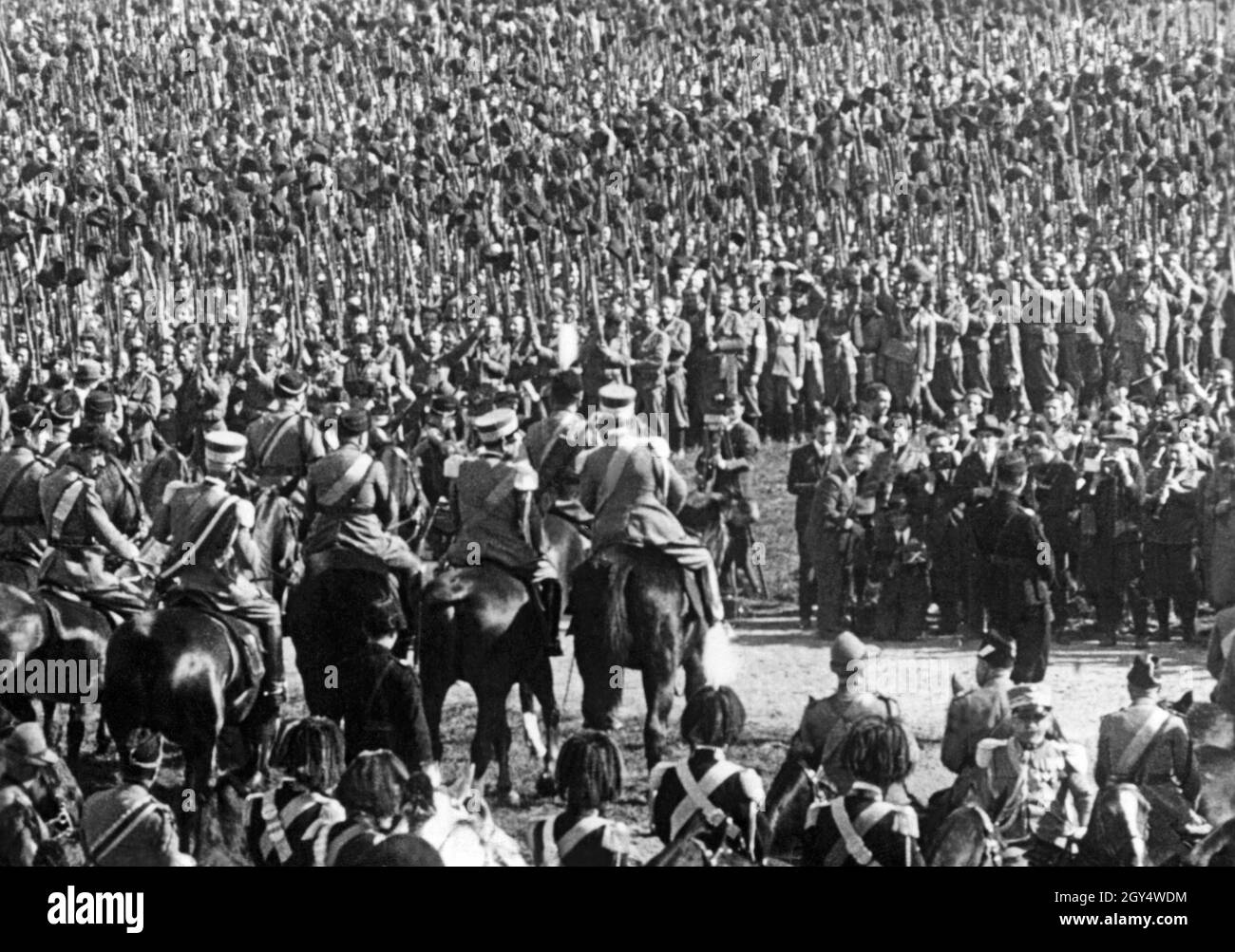 Benito Mussolini (Mitte, Hut mit Hut) sprach im Herbst 1927 im Park der Villa Glori in Rom Soldaten der italienischen Armee an. Anlass war die Feier des 5. Jahrestages des Faschismus (nach dem marsch nach Rom im Oktober 1922). Auf der rechten Seite sind ein Filmteam und die Pressefotografen zu sehen. Die Aufnahme stammt aus einem Bild in einer Ufa-Wochenschau. [Automatisierte Übersetzung] Stockfoto