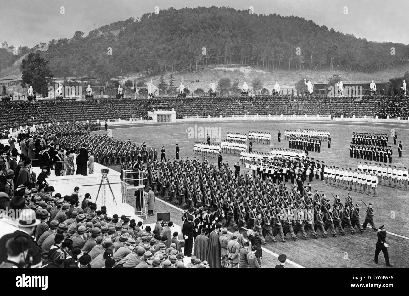 Hermann Göring beobachtet zusammen mit Benito Mussolini den marsch faschistischer Einheiten der Opera nazionale balilla. Die beiden stehen auf der linken Seite der Tribüne in der ersten Reihe. Sie befinden sich im Marmorstadion (dann Foro Mussolini) in Rom. Undatierte Fotografie, wahrscheinlich um 1940 aufgenommen. [Automatisierte Übersetzung] Stockfoto