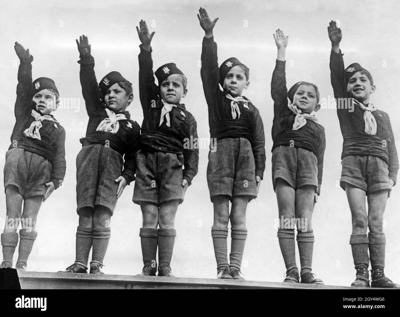 "Nach dem "Beispiel" der Erwachsenen zeigen sich diese Kinder bereits im Einklang mit der italienischen faschistischen Partei und präsentieren 1934 den römischen Gruß. Die Kinder tragen die Uniformen der faschistischen Jugendorganisation Opera Nazionale Balilla. Die jüngsten wurden ''Figli della Lupa'' genannt. [Automatisierte Übersetzung]' Stockfoto