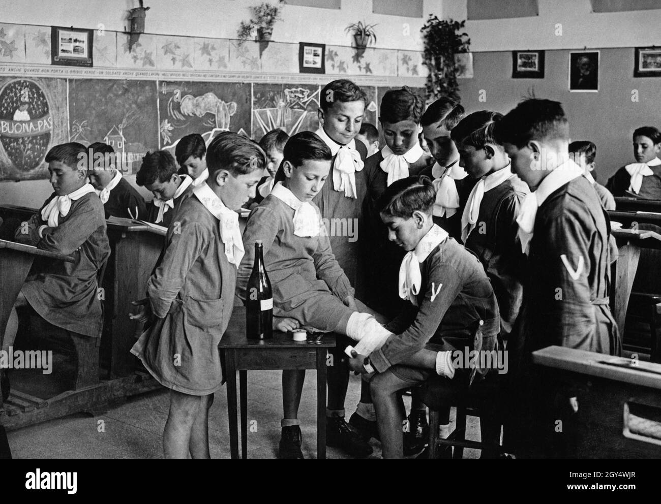 Italienische Schulen hielten Unterricht für Schüler ab, um wichtige  Hygienevorschriften und medizinische Hilfe zu erlernen. Dieses Bild aus dem  Jahr 1935 zeigt Studenten, wie sie eine Wunde mit Alkohol desinfizieren und  eine