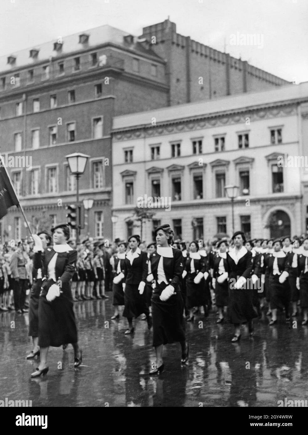 'Eine Parade von 1200 jungen italienischen Faschisten und jungen faschistischen Frauen der Opera Nazionale Balilla (Jugendorganisation der italienischen Faschisten) marschierte am 16. Juni 1937 durch Berlin-Mitte zum Wilhelmplatz, wo Hitler eine Rede hielt. Das Bild zeigt junge Frauen, die sogenannte "Giovani Fasciste", die durch den Boulevard unter den Linden, Ecke Wilhelmstraße marschiert (im Hintergrund die Gebäude unter den Linden Nr. 78-80). Auf der linken Seite sind Zuschauer, darunter einige Hitler Youth. [Automatisierte Übersetzung]' Stockfoto