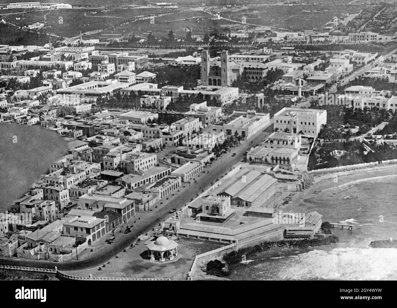 Die Luftaufnahme zeigt das Zentrum der Kolonialstadt Mogadischu, der Hauptstadt des italienischen Somaliland. Links hinter der Kirche befindet sich ein Flugplatz. Der Hafen der Stadt war ein Marinestützpunkt für die italienische Marine. Das undatierte Foto wurde wahrscheinlich in den 1930er Jahren aufgenommen. [Automatisierte Übersetzung] Stockfoto