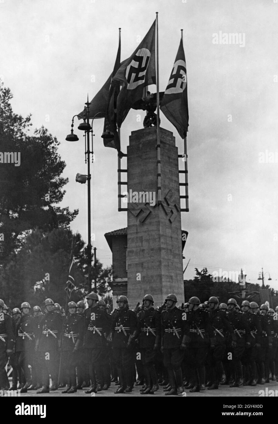 1938 besuchte eine faschistische Delagation aus Italien Berlin, die Hauptstadt des alliierten Nazi-Deutschlands. Auf dem Bild stehen die Offiziere in Formation vor einer Säule mit Hakenkreuzsymbolen. [Automatisierte Übersetzung] Stockfoto