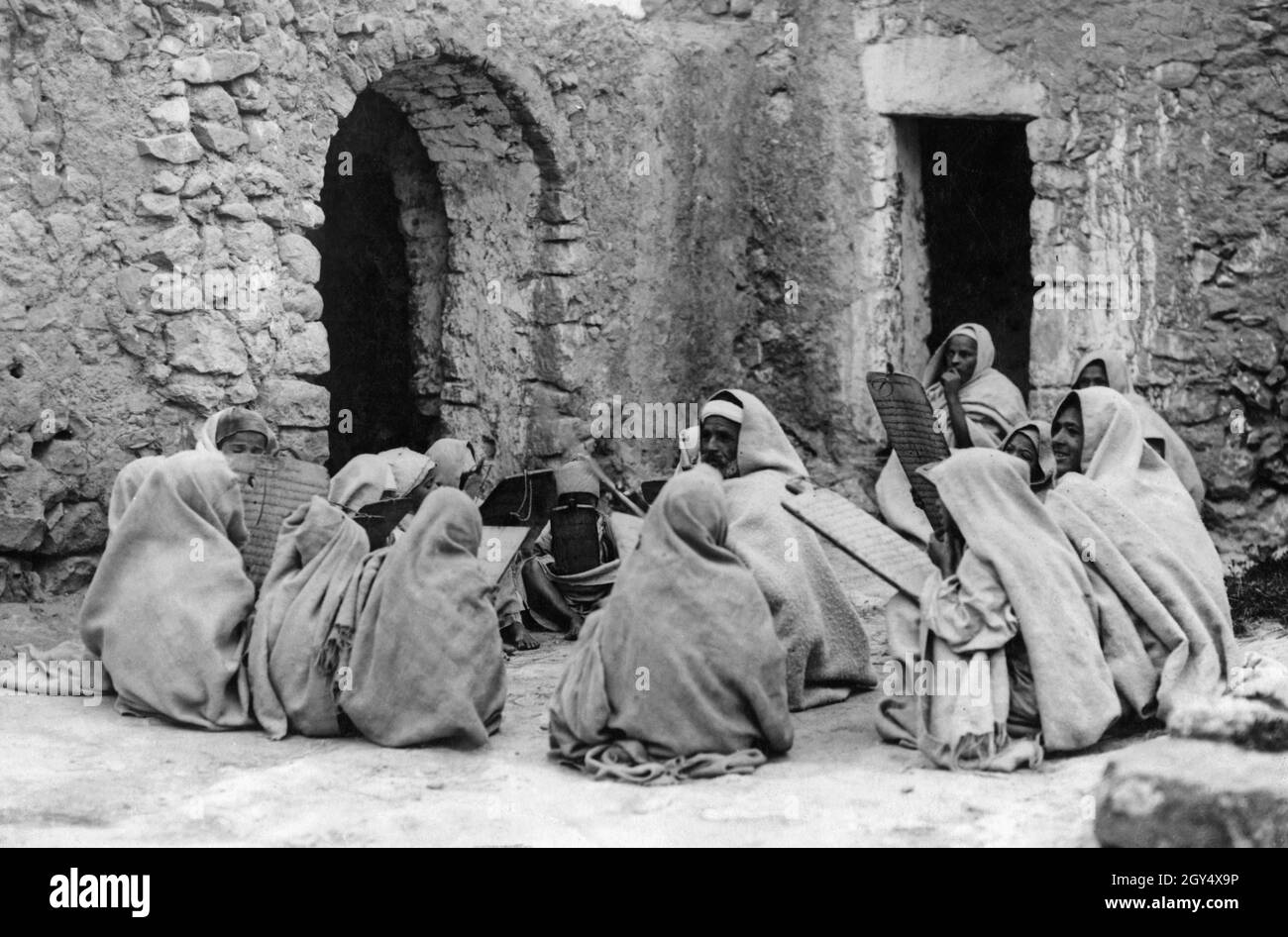 Die Schüler einer Koranschule in Libyen sitzen zusammen und studieren Schriftbögen. Sie sitzen in einem Kreis in einer Gruppe. [Automatisierte Übersetzung] Stockfoto