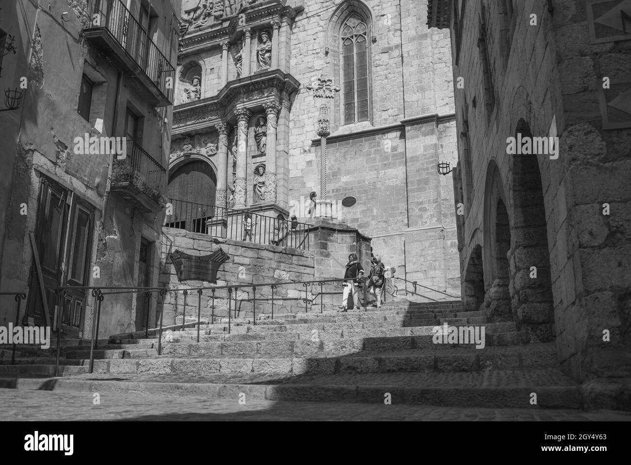 MONTBLANC - SPANIEN - 12. SEPTEMBER 2021: Schwarz-weißes Straßenbild mit Stufen zur Kirche mit Menschen im historischen Viertel Dorf Montblanc Stockfoto