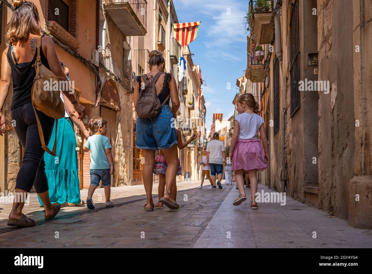 MONTBLANC, SPANIEN - SEPTEMBER 12.2021: Alte Straße mit einer Familie mit Kindern im historischen Viertel des antiken spanischen Dorfes Montblanc. Catalon Stockfoto