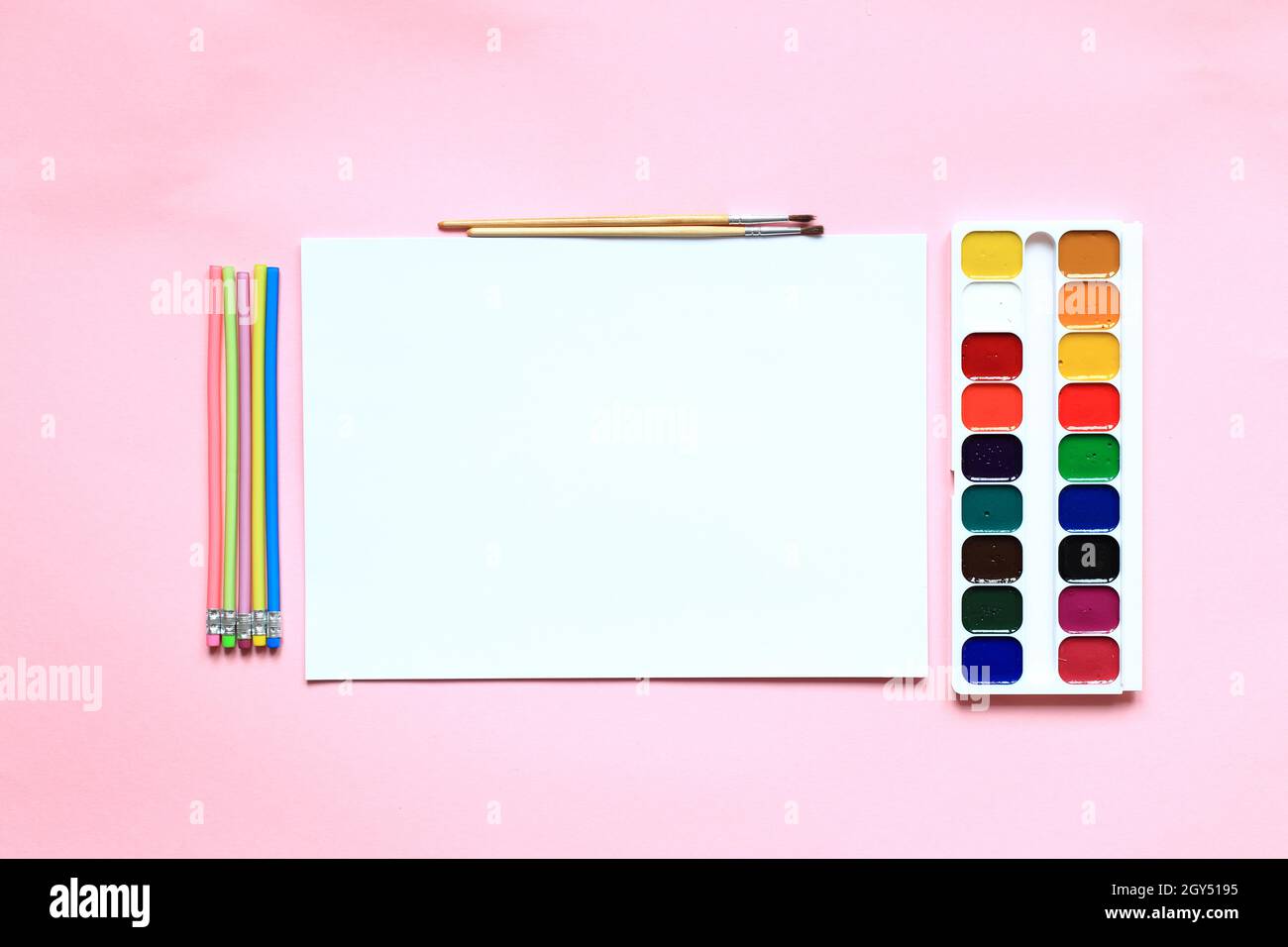 Eine Reihe von Farben und Bleistiften zum Zeichnen auf einem rosa Hintergrund. Schreibwaren für die Schule. Layout der Waren für den Künstler. Blick von oben. Stockfoto