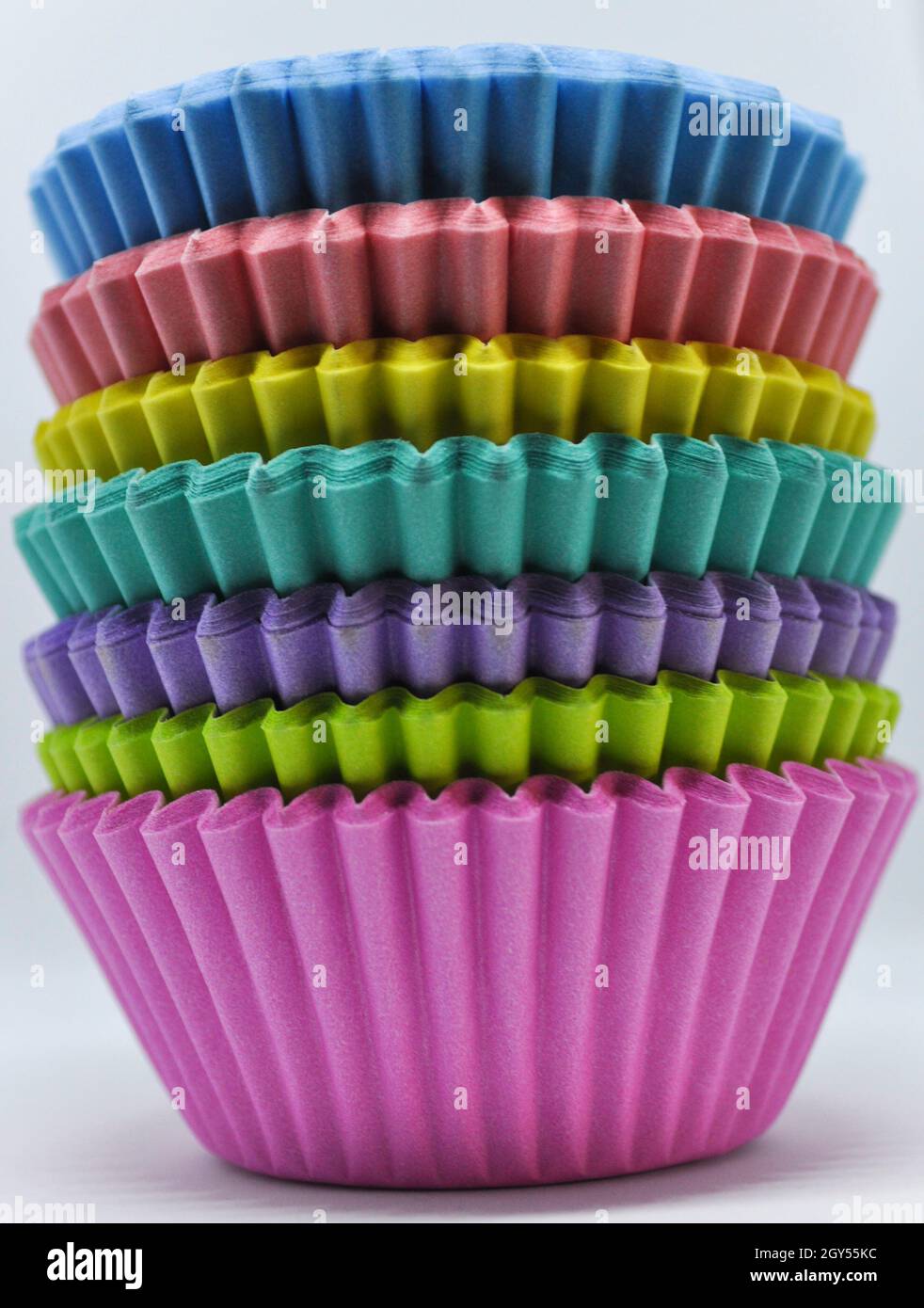 Stapel von Regenbogen Tasse Kuchen Fällen vor einem weißen Hintergrund gesetzt Stockfoto