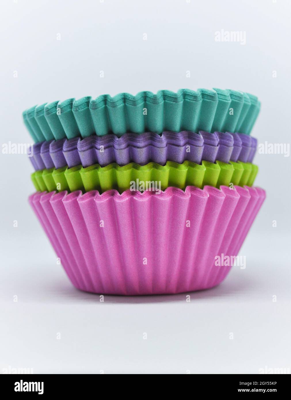 Stapel von Regenbogen Tasse Kuchen Fällen vor einem weißen Hintergrund gesetzt Stockfoto