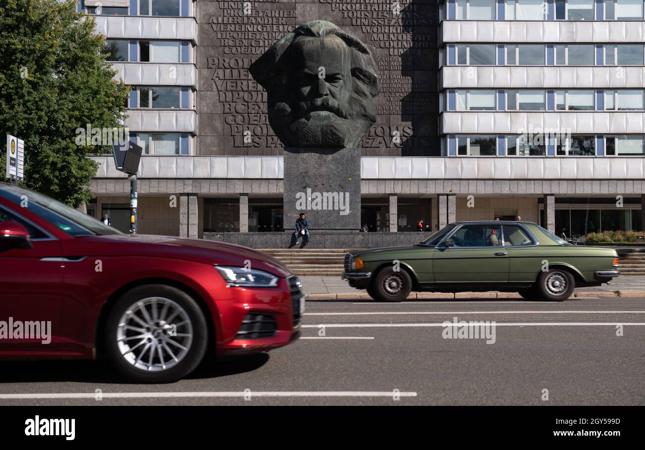Chemnitz, Deutschland. Oktober 2021. Autos fahren vor dem Karl-Marx-Denkmal im Zentrum von Chemnitz vorbei. Die 'Nischel', wie die Chemnitzer ihre riesige Marx-Skulptur nennen, ziert Stempel, Becher und Kreditkarten. Jetzt wird er 50. Der 40 Tonnen schwere, riesige bronzene Philosoph-Kopf gilt als die zweitgrößte Porträtbüste der Welt. Es wurde vom russischen Bildhauer Lew Curbel (1917-2003) geschaffen und am 9. Oktober 1971 vor 250,000 Menschen enthüllt. Quelle: Hendrik Schmidt/dpa-Zentralbild/dpa/Alamy Live News Stockfoto