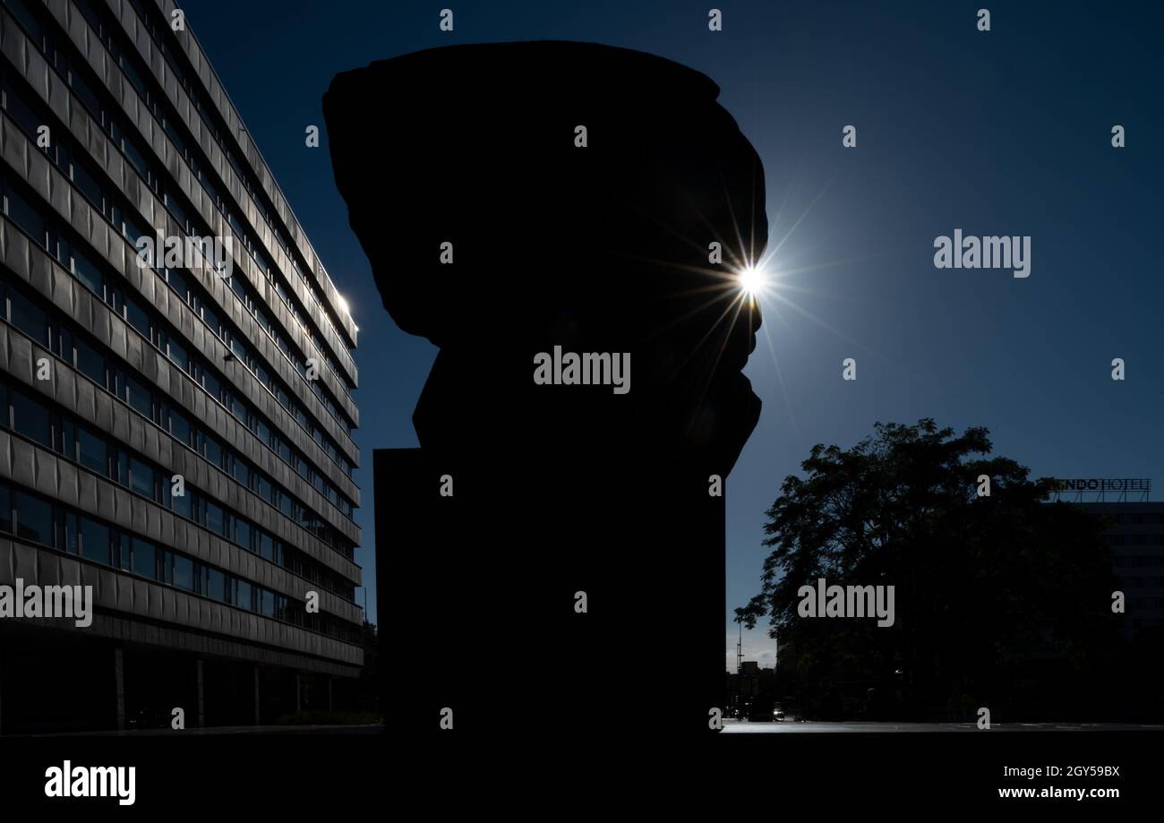 Chemnitz, Deutschland. Oktober 2021. Im Gegenlicht der Sonne ragt die Silhouette des Karl-Marx-Denkmals im Zentrum von Chemnitz hervor. Die 'Nischel', wie die Chemnitzer ihre riesige Marx-Skulptur nennen, ziert Stempel, Tassen und Kreditkarten. Jetzt wird er 50. Der 40 Tonnen schwere, riesige bronzene Philosoph-Kopf gilt als die zweitgrößte Porträtbüste der Welt. Es wurde vom russischen Bildhauer Lew Curbel (1917-2003) geschaffen und am 9. Oktober 1971 vor 250,000 Menschen enthüllt. Quelle: Hendrik Schmidt/dpa-Zentralbild/dpa/Alamy Live News Stockfoto