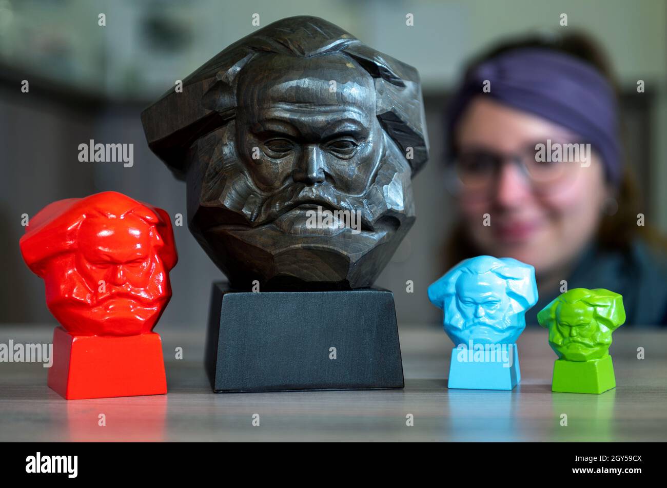 Chemnitz, Deutschland. Oktober 2021. Miniaturbüsten des Karl-Marx-Denkmals werden in der Tourist-Information in Chemnitz verkauft. Die 'Nischel', wie die Chemnitzer ihre riesige Marx-Skulptur nennen, ziert Stempel, Tassen und Kreditkarten. Jetzt wird er 50. Der 40 Tonnen schwere, riesige bronzene Philosoph-Kopf gilt als die zweitgrößte Porträtbüste der Welt. Es wurde vom russischen Bildhauer Lew Curbel (1917-2003) geschaffen und am 9. Oktober 1971 vor 250,000 Menschen enthüllt. Quelle: Hendrik Schmidt/dpa-Zentralbild/dpa/Alamy Live News Stockfoto