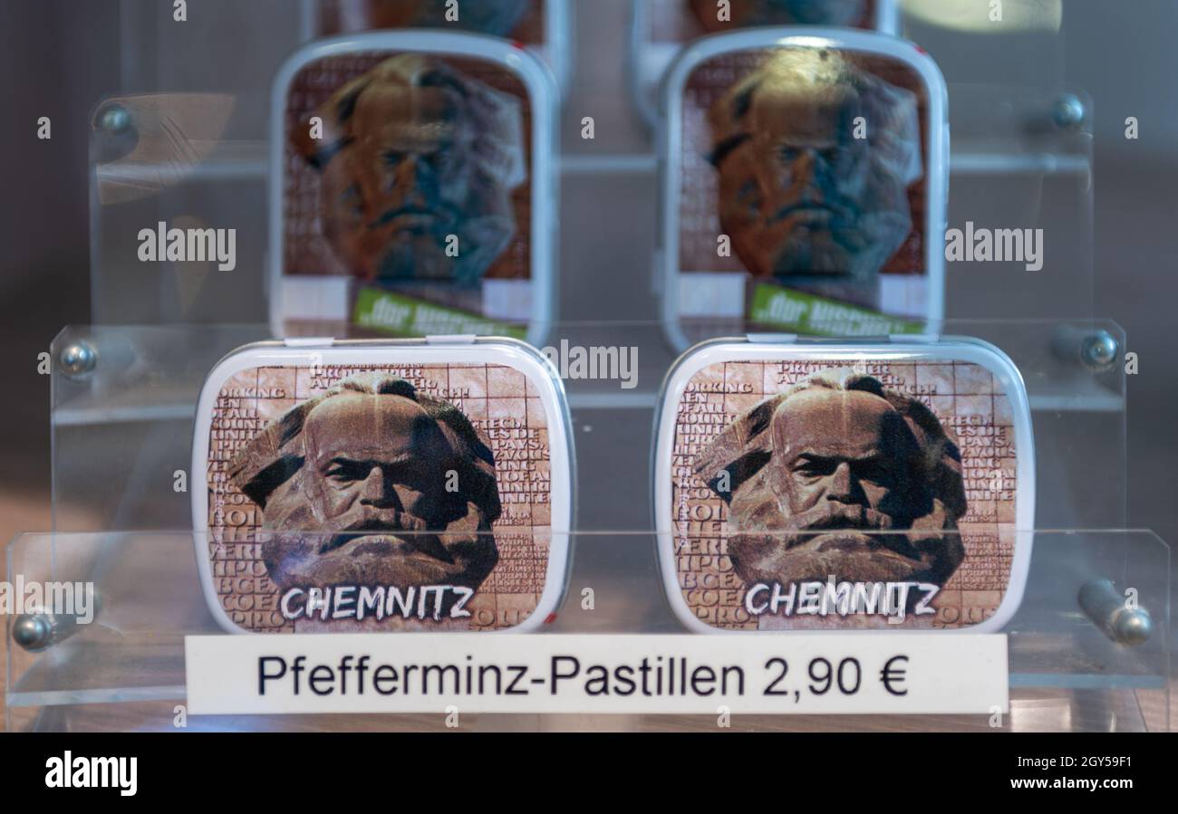 Chemnitz, Deutschland. Oktober 2021. Pfefferminzpastillen in einer Dose mit einem Bild des Karl-Marx-Denkmals sind in der Tourist-Information in Chemnitz zu sehen. Die 'Nischel', wie die Chemnitzer ihre riesige Marx-Skulptur nennen, ziert Stempel, Becher und Kreditkarten. Jetzt wird er 50. Der 40 Tonnen schwere, riesige bronzene Philosoph-Kopf gilt als die zweitgrößte Porträtbüste der Welt. Es wurde vom russischen Bildhauer Lew Curbel (1917-2003) geschaffen und am 9. Oktober 1971 vor 250,000 Menschen enthüllt. Quelle: Hendrik Schmidt/dpa-Zentralbild/dpa/Alamy Live News Stockfoto