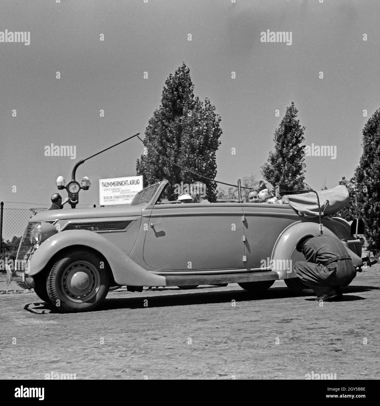 Ein Servicemitarbeiter einer Aral Tankstelle in Berlin Charlottenburg überprüft den Luftdruck in den Reifen ein 1963 Cabrio, Deutschland 1930er Jahre. Ein Füllungen Tankwart Kontrolle der Inflation der Druck auf ein Cabrio, Deutschland 1930. Stockfoto