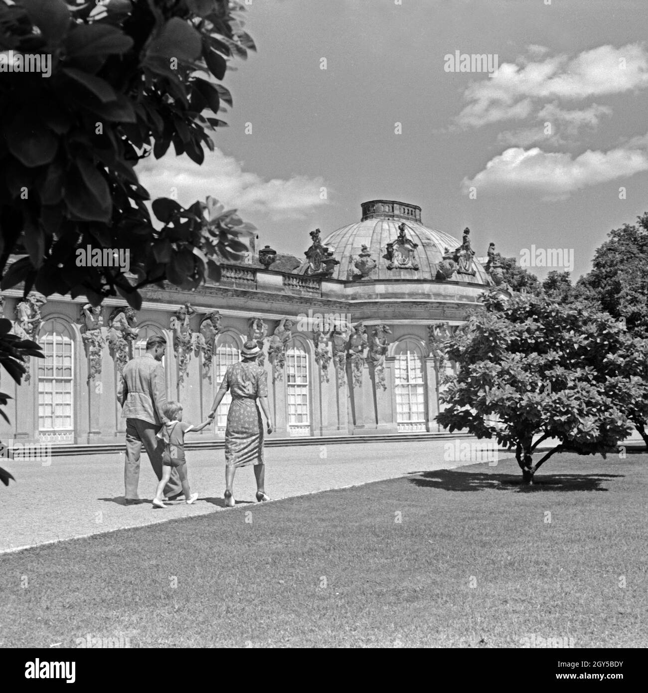 Eine Familie spaziert an der Südseite von Schloß Sanssouci in Potsdam bei Berlin, Deutschland, 1930er Jahre. Ein Familienspaziergang auf Schloss Sanssouci in Potsdam bei Berlin, Deutschland 1930er Jahre. Stockfoto