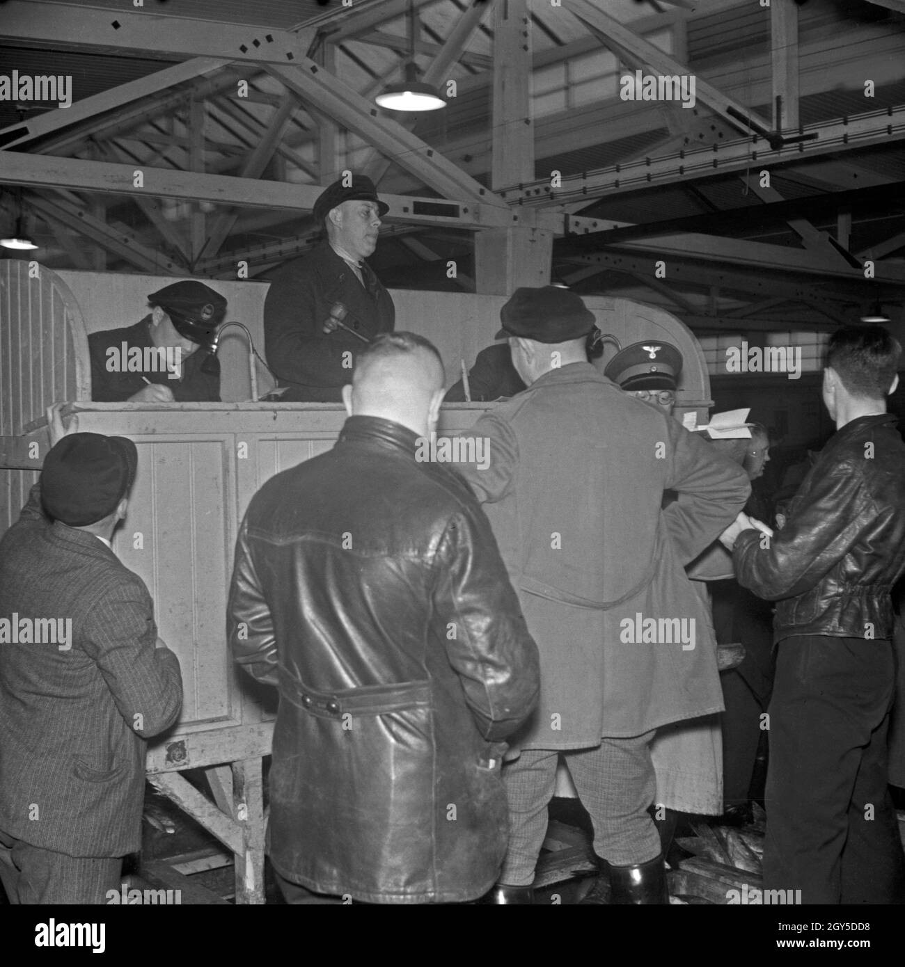 24 Stunden Reportage: Betrieb im Fischereihafen Wesermünde, Fischhändler platzieren ihre Gebote beim Auktionator, Deutschland 1930er Jahre. 24 Stunden Abdeckung leben vom Fischereihafen Wesermünde; Fischhändler, die ihre Gebote auf die Acution abgeben, Deutschland 1930er Jahre. Stockfoto