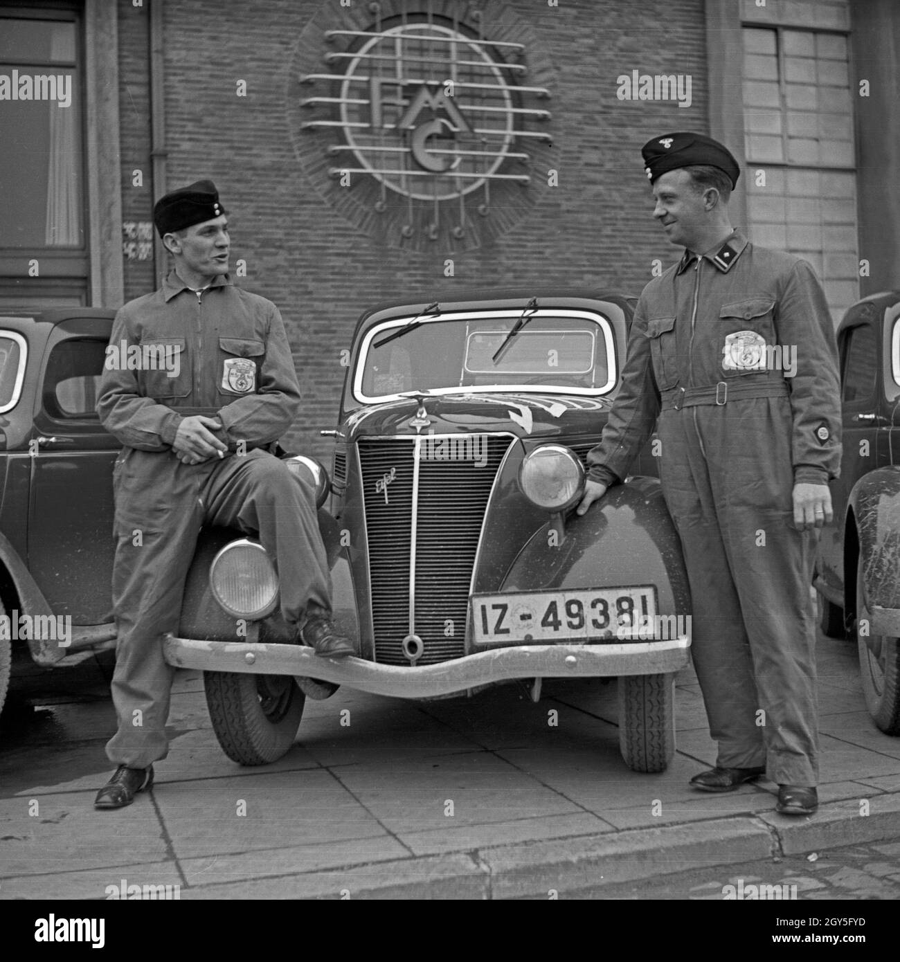 Ein Fahrerteam mit seinem Ford Eifel der Firmenzentrale der Ford Werke in Köln Niehl, Deutschland 1930er Jahre. Ein Fahrer Team mit seinem Ford Modell Eifel vor der Deutschen Ford Zentrale in Köln, Deutschland 1930. Stockfoto