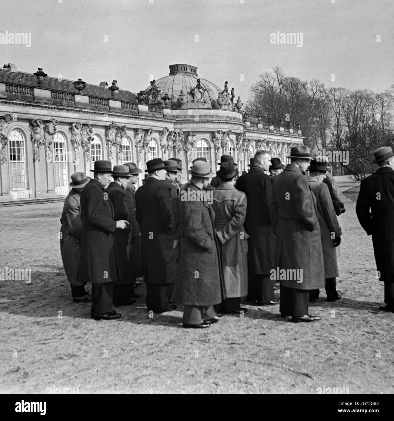 Eine Reisegruppe bei der Besichtigung von Schloß Sanssouci in Potsdam bei Berlin, Deutschland 1930er Jahre. Eine Gruppe von Reisenden bei ihrer Besichtigungstour durch Schloss Sanssouci in Potsdam bei Berlin, Deutschland 1930er Jahre. Stockfoto