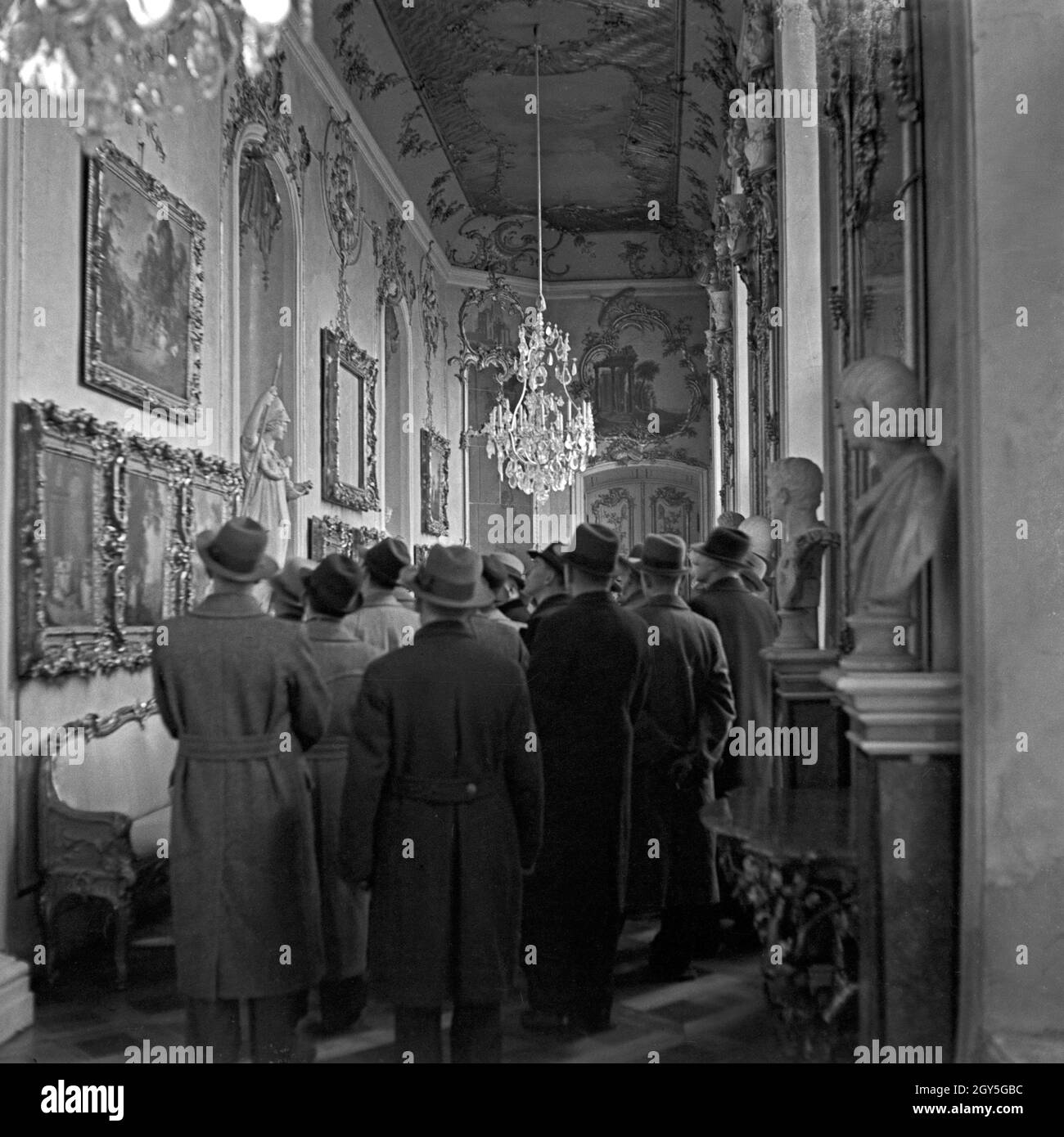 Eine Reisegruppe besichtigte das Innere von Schloß Sanssouci in Potsdam bei Berlin, Deutschland 1930er Jahre. Eine Gruppe von Reisenden besucht das Innere des Schlosses Sanssouci in Potsdam bei Berlin, Deutschland 1930er Jahre. Stockfoto