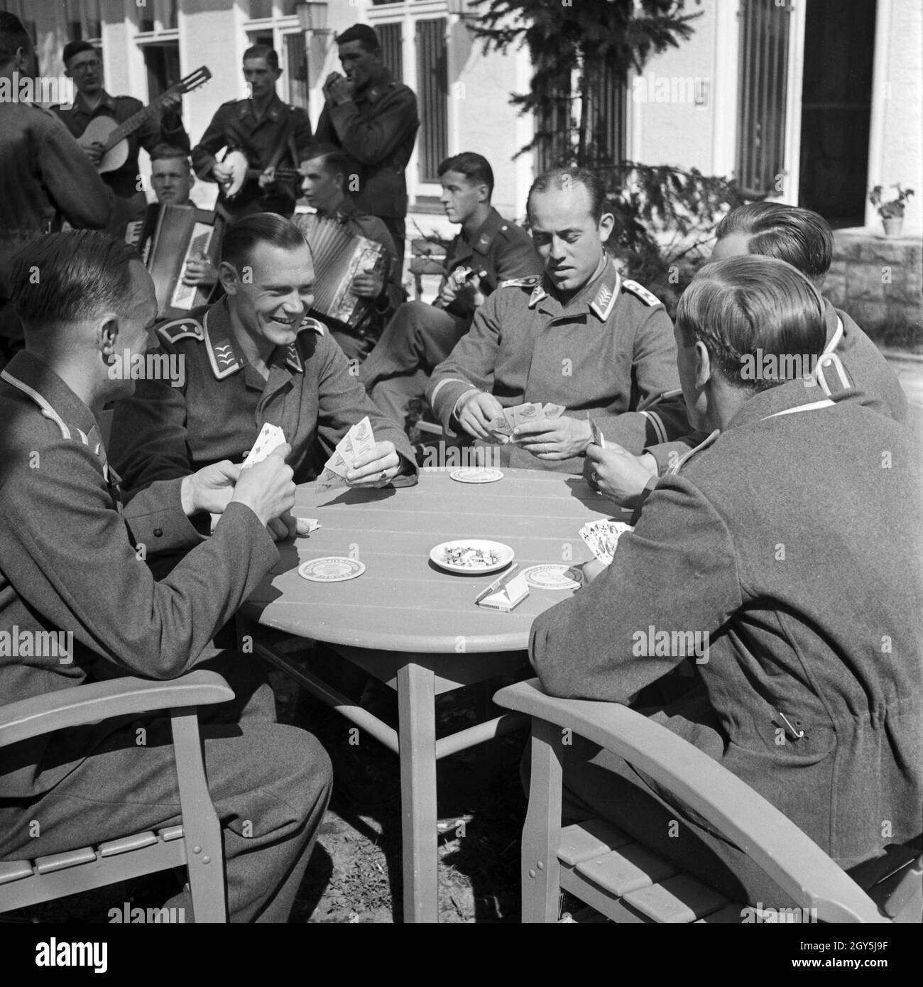 Original-Bildunterschrift: Gemütlicher Skat in der Freizeit. Sterben Horstkapelle sorgt für die musikalische Untermalung, Deutschland 1940er Jahre. Feine spielen Skat in Ihrer freien Zeit. Die Horst Combo spielen Musik, Deutschland 1940. Stockfoto