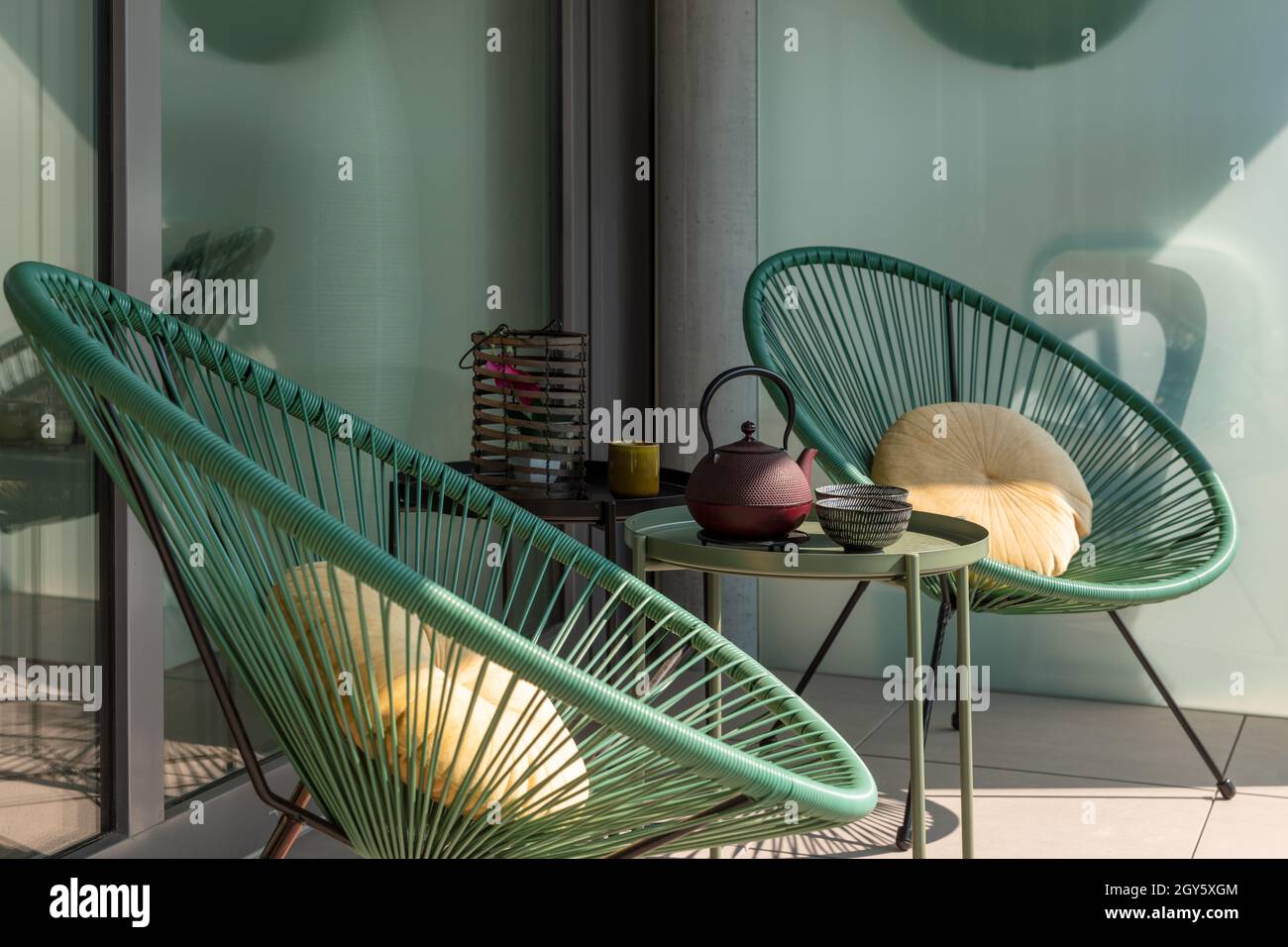 Elegante Ecke einer Terrasse eines modernen Hauses mit zwei Sesseln und einem chinesischen Tee mit zwei Tassen. Sonniger Sommertag Stockfoto